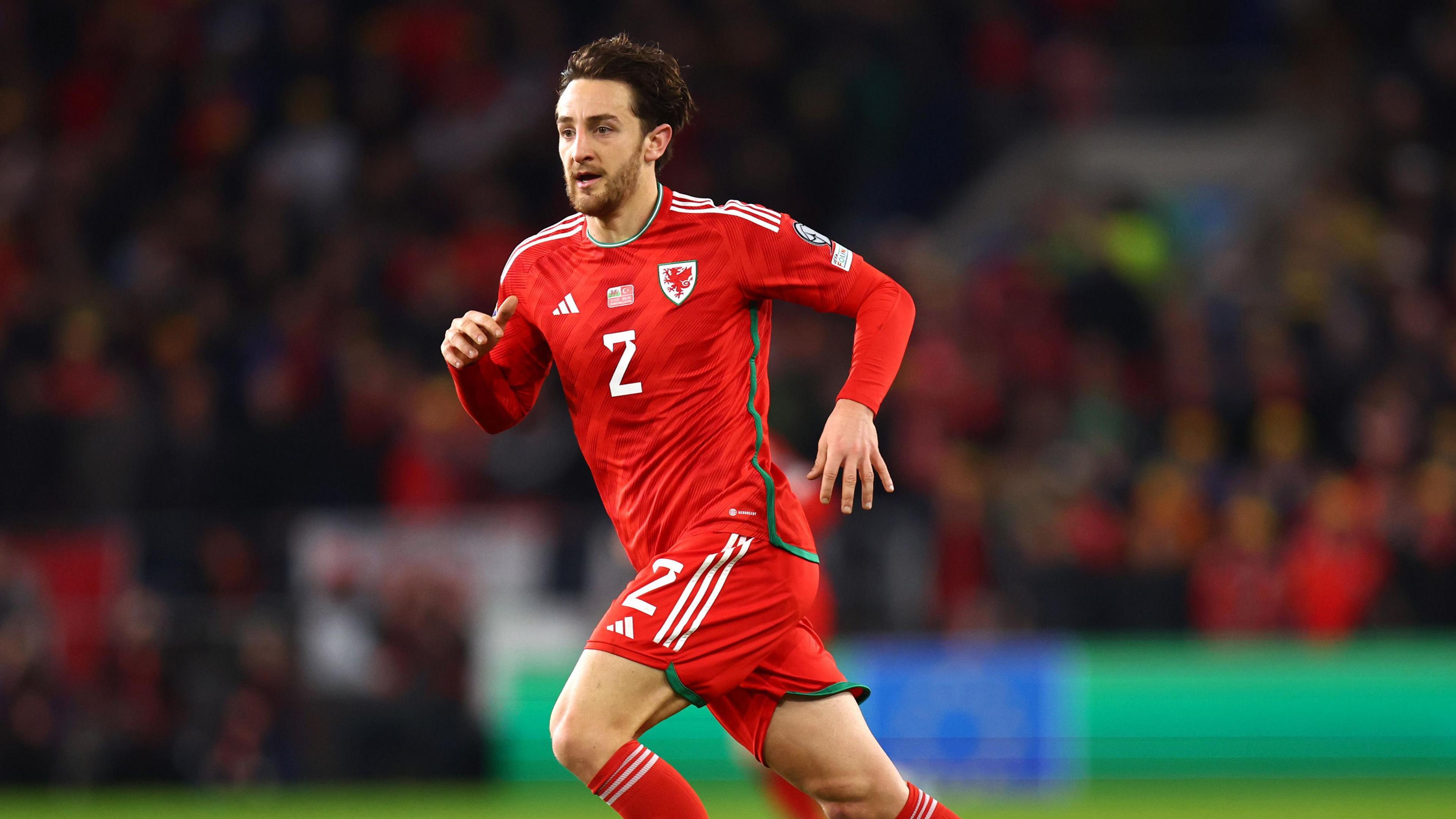 Tom Lockyer running on the pitch during a match for Wales