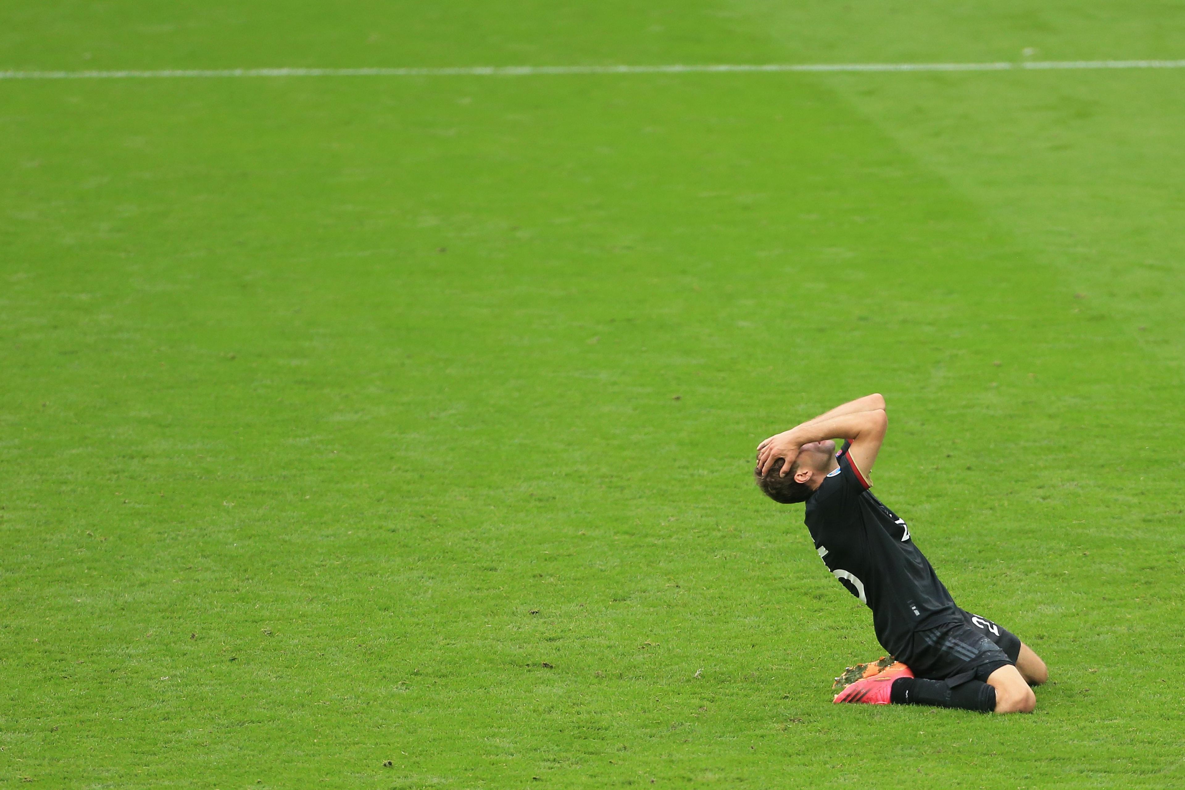 Thomas Muller holds his head in his hands after putting his shot wide