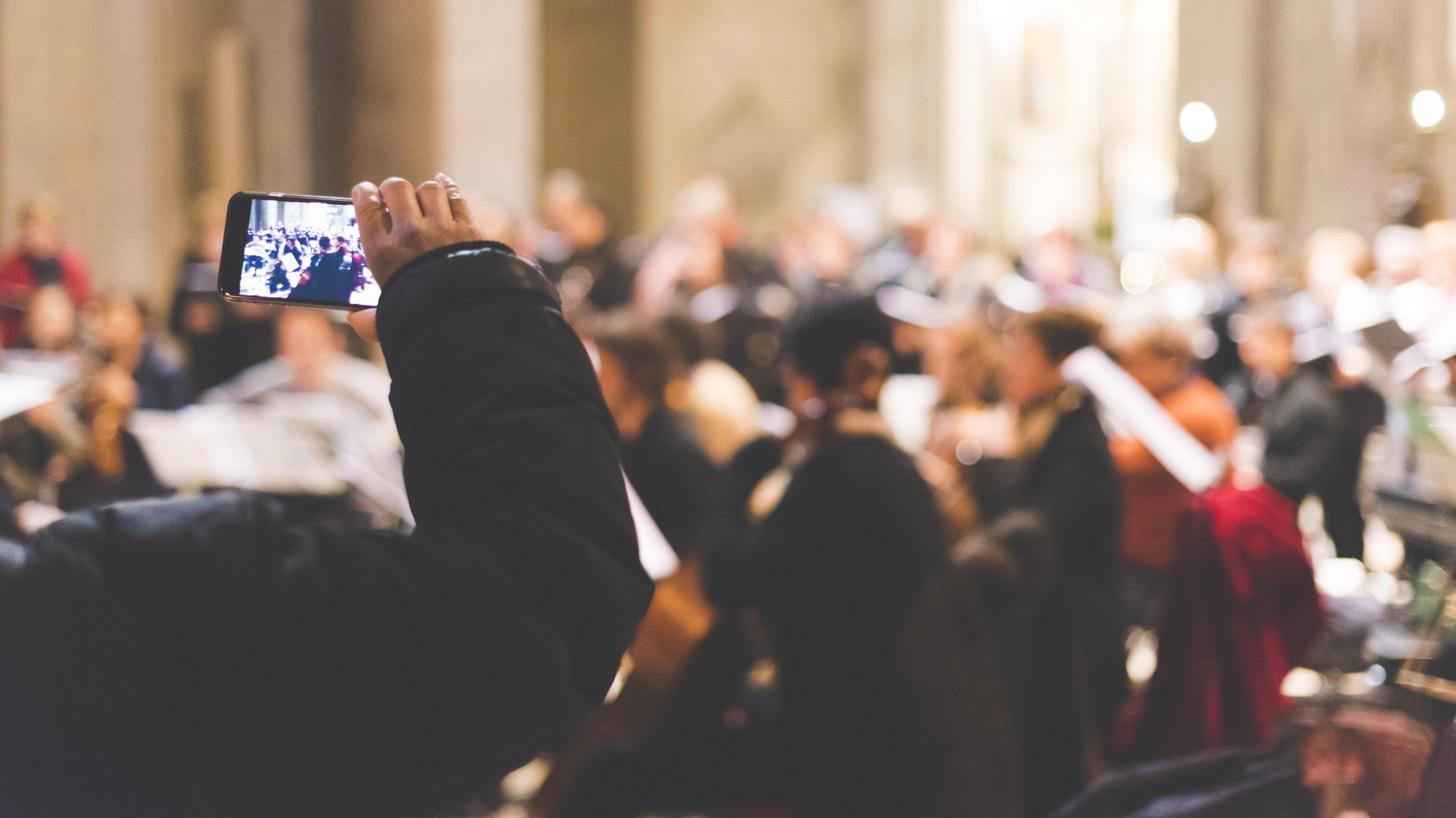 A phone being held up to film a concert