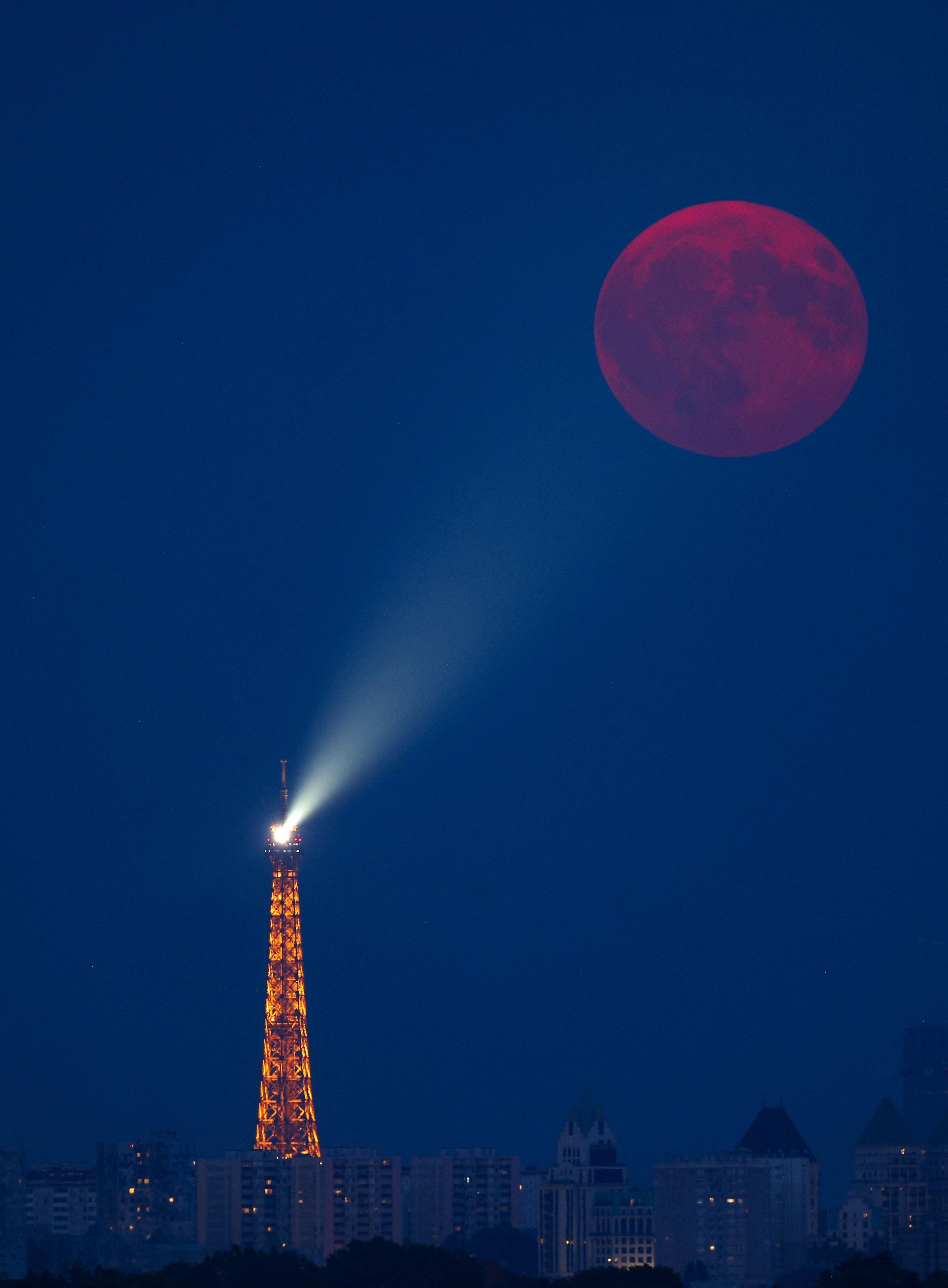 The full moon known as the "Buck Moon" rises over the Eiffel Tower, as seen from Maisons Laffitte, France