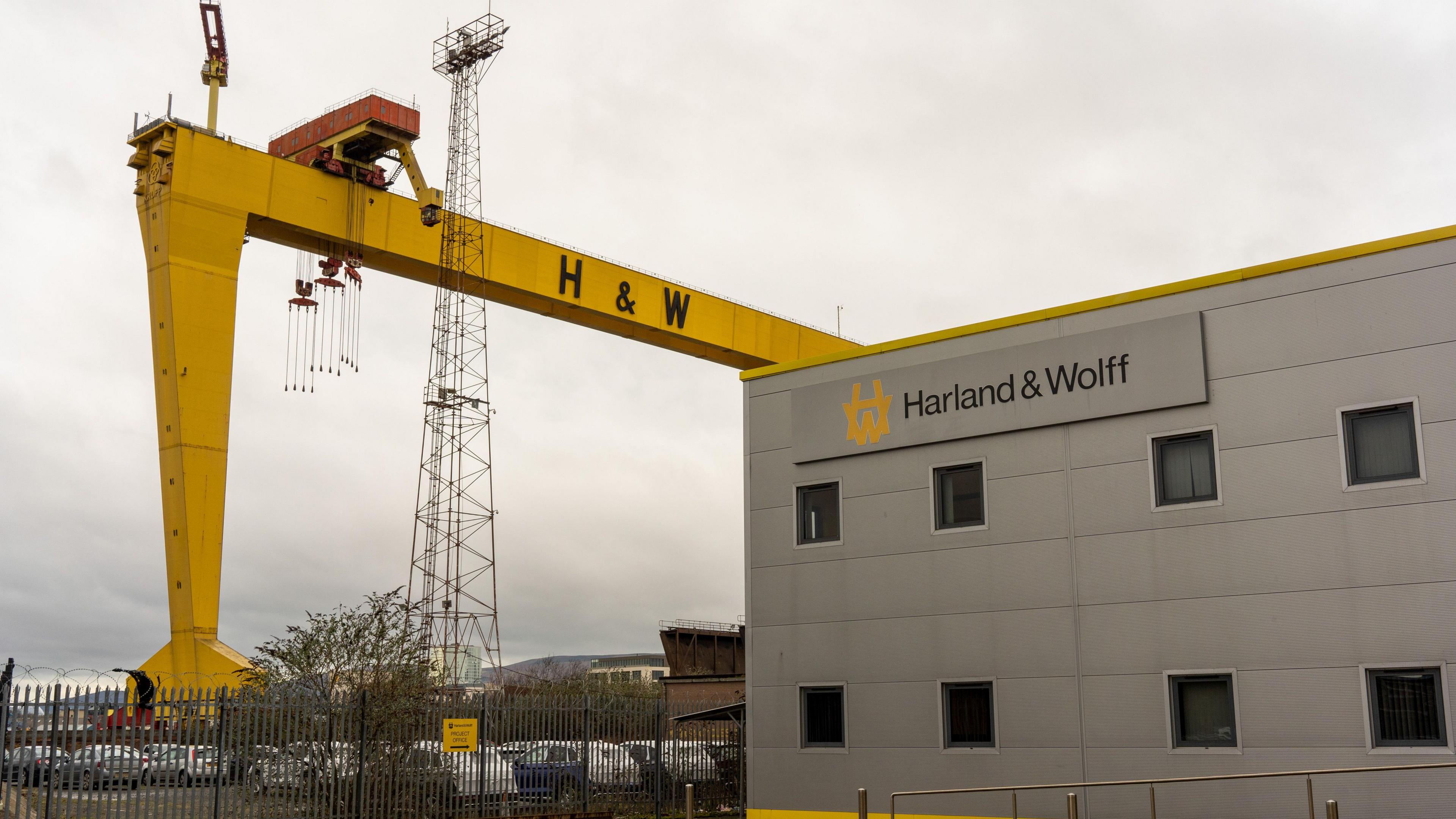 One of the iconic Harland & Wolff Samson and Goliath yellow gantry cranes near the entrance to the Harland & Wolff Group Holdings shipyard in Belfast. The sky is cloudy.