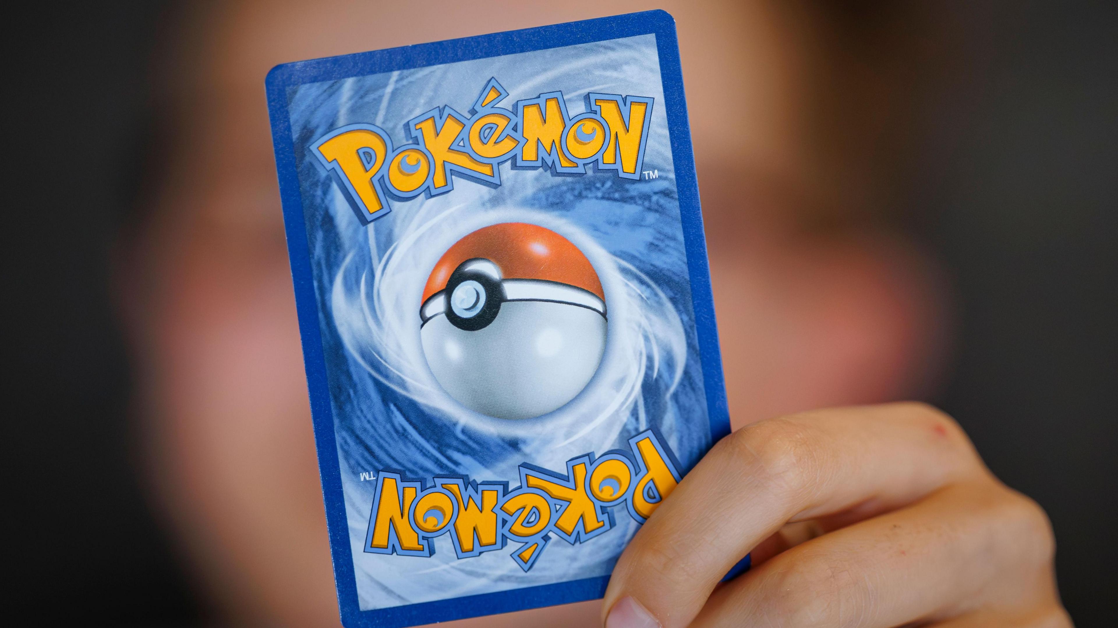 Fan holds up a Pokémon card