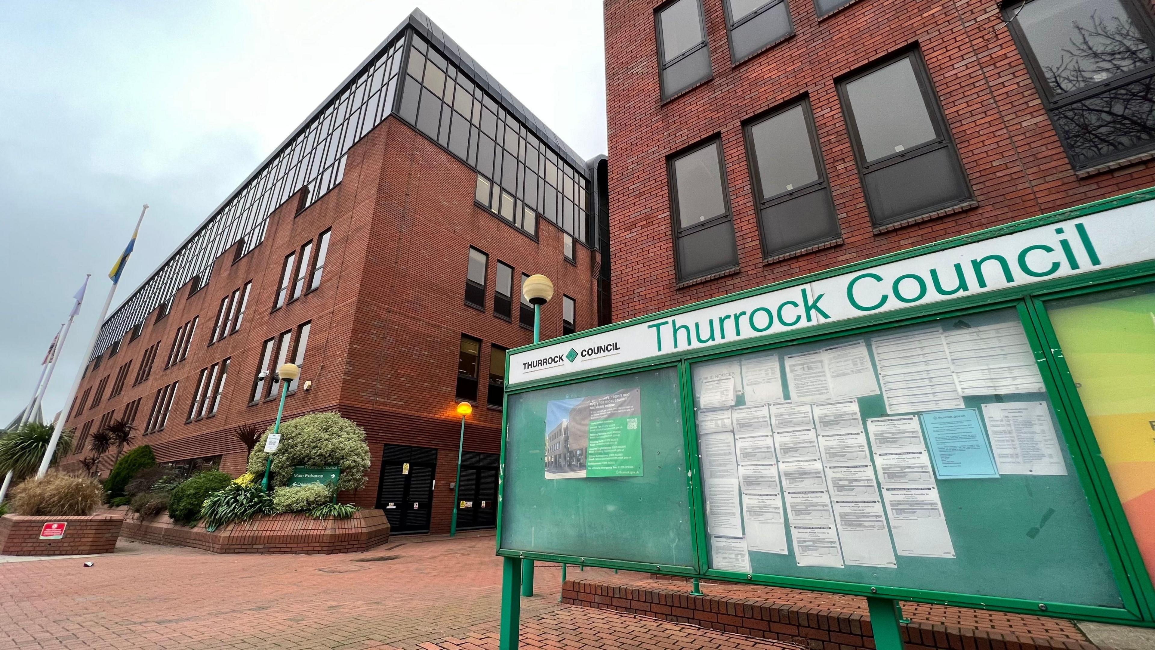 Thurrock Council offices. There is a green sign saying Thurrock Council outside the buildings.
There are notices on the greenboard