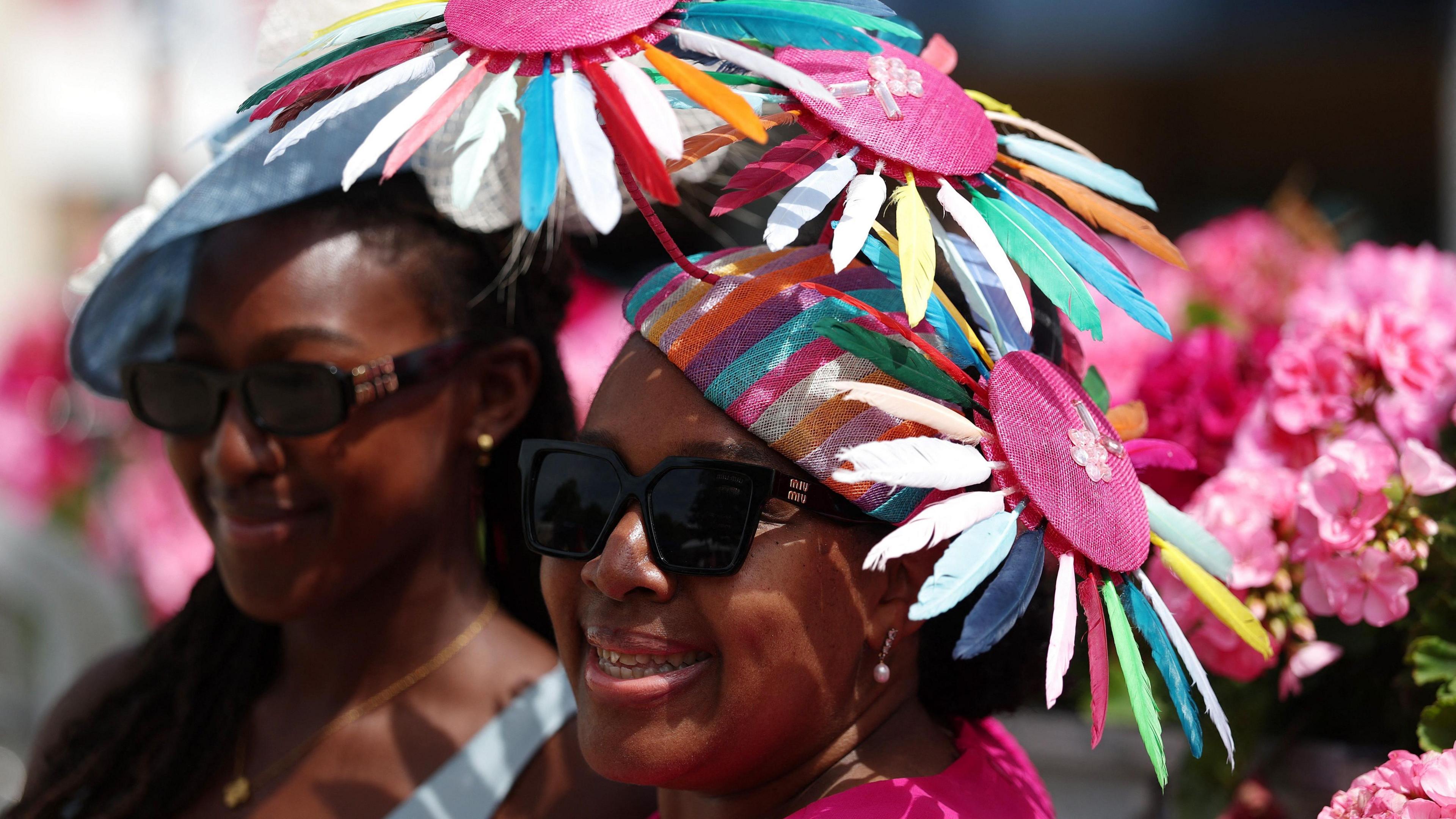 Two women wearing hats which appear to be inspired by sunflowers, smiling for the camera.