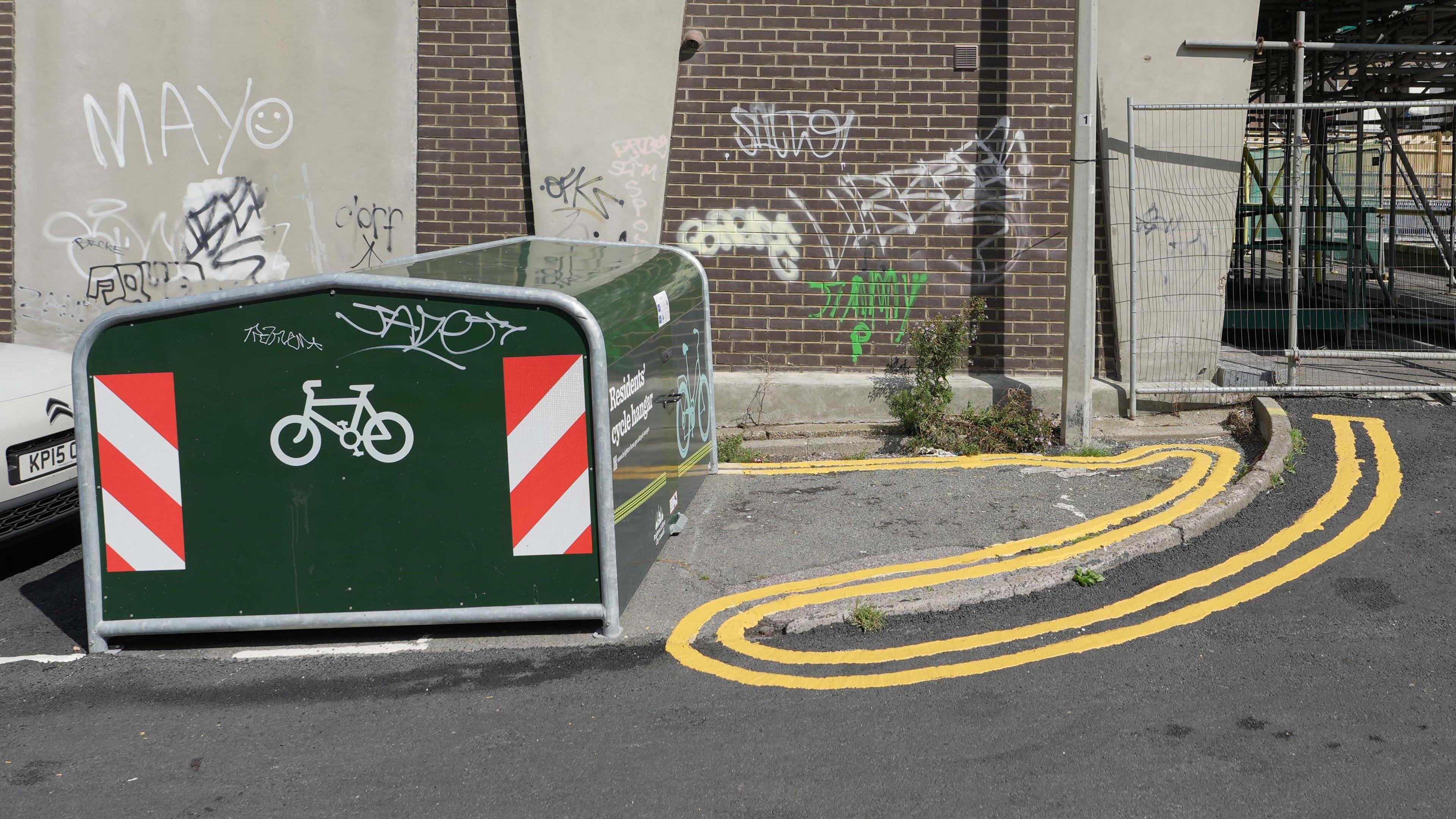 Double yellow lines snaking back on themselves around a curb are viewed from a side angle. 