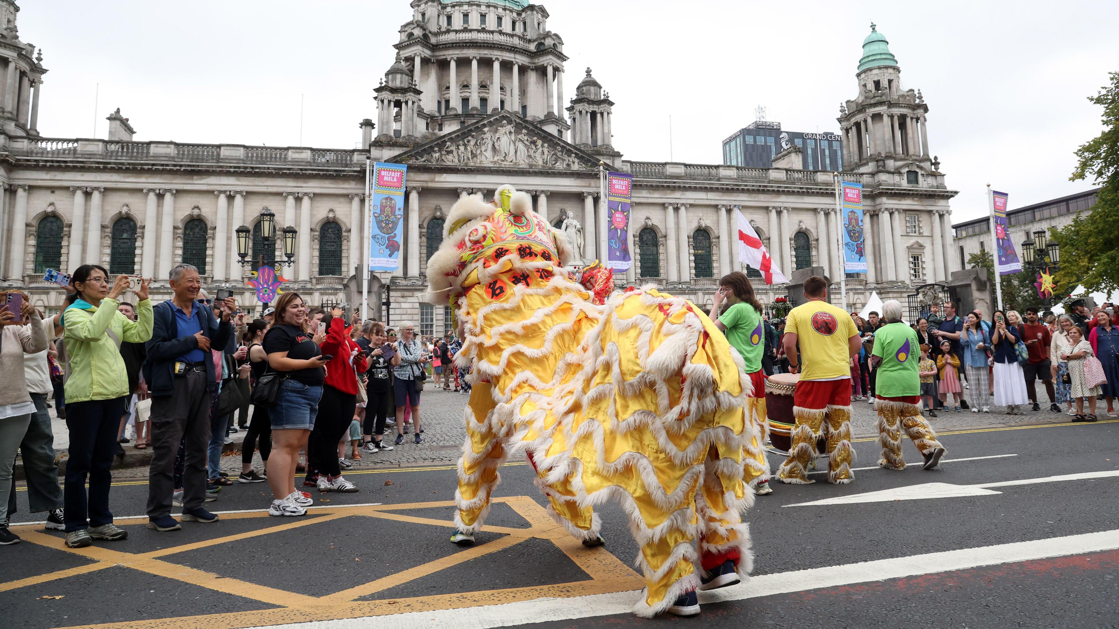 A Chinese dragon is dancing in front of Belfast City Hall.