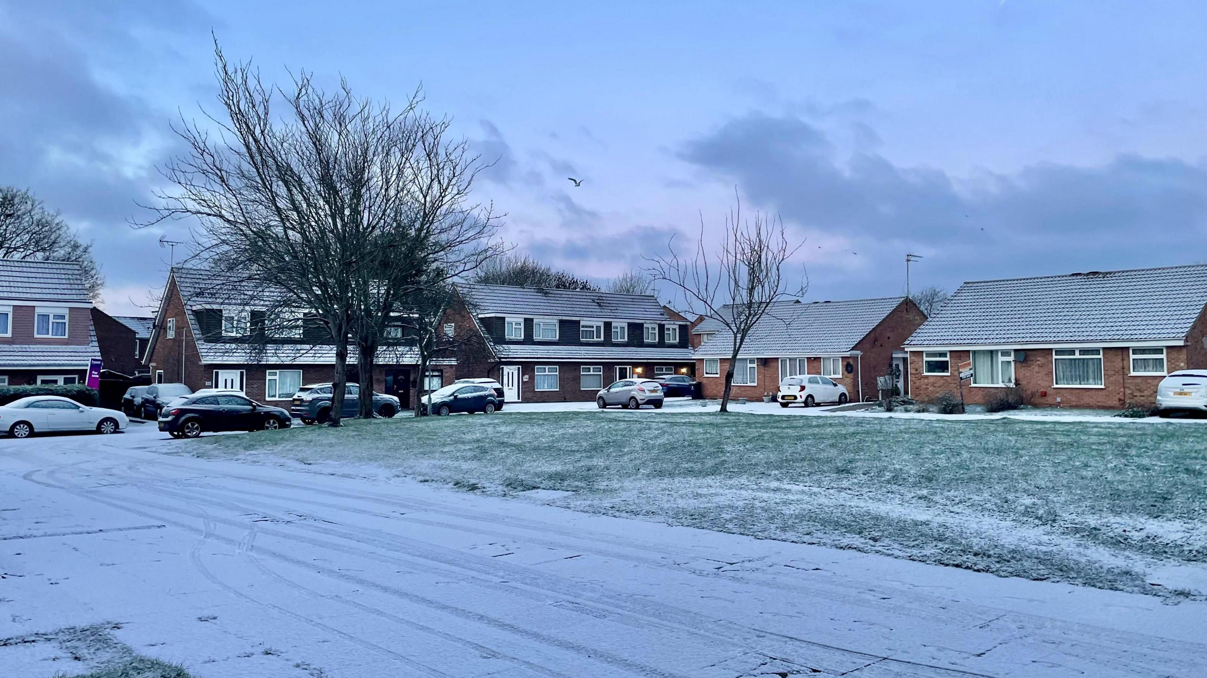 Residential street covered in a light dusting of snow
