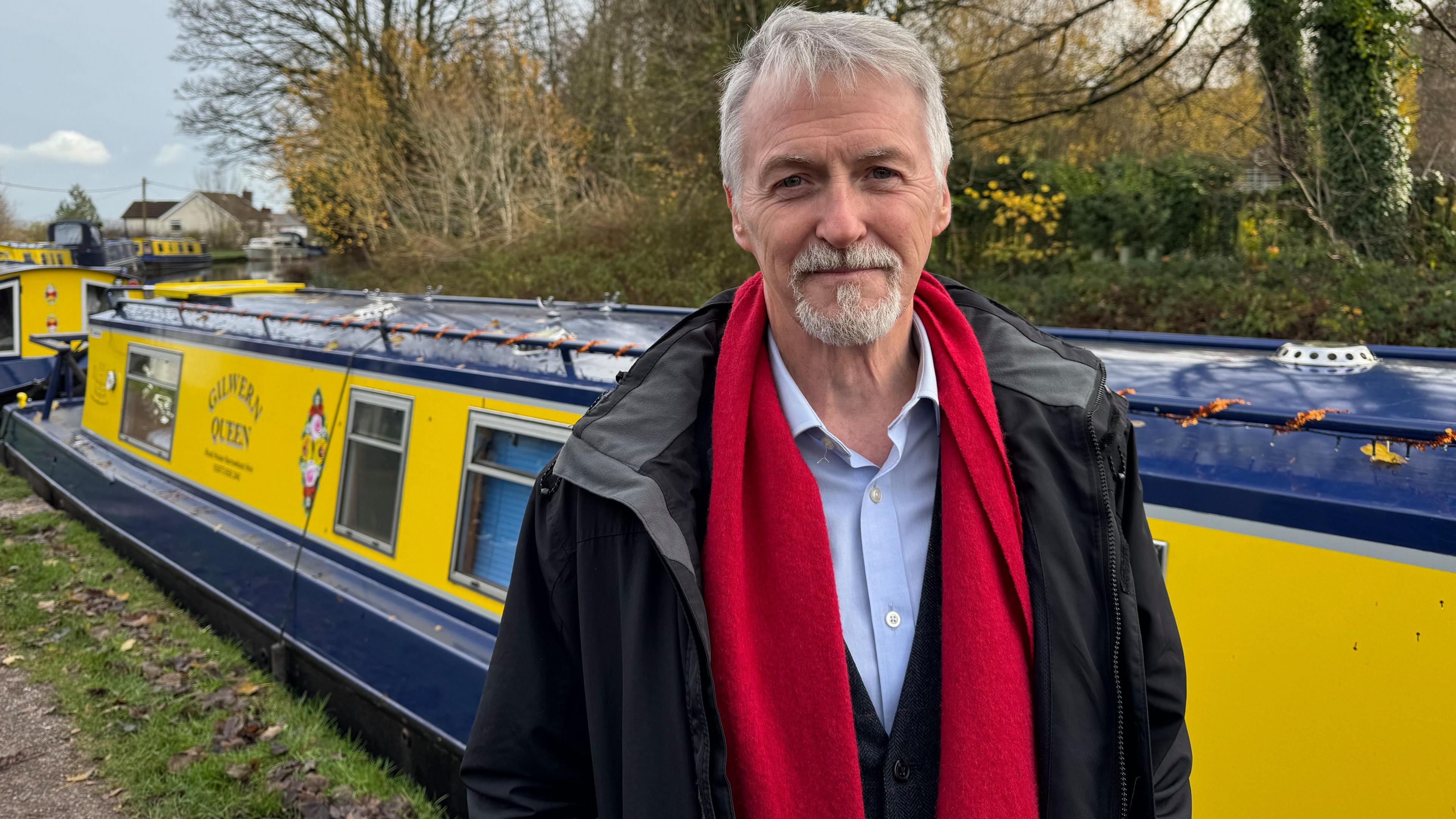 Y dirprwy Brif Weinidog Huw Irranca-Davies o flaen bad ar y gamlas