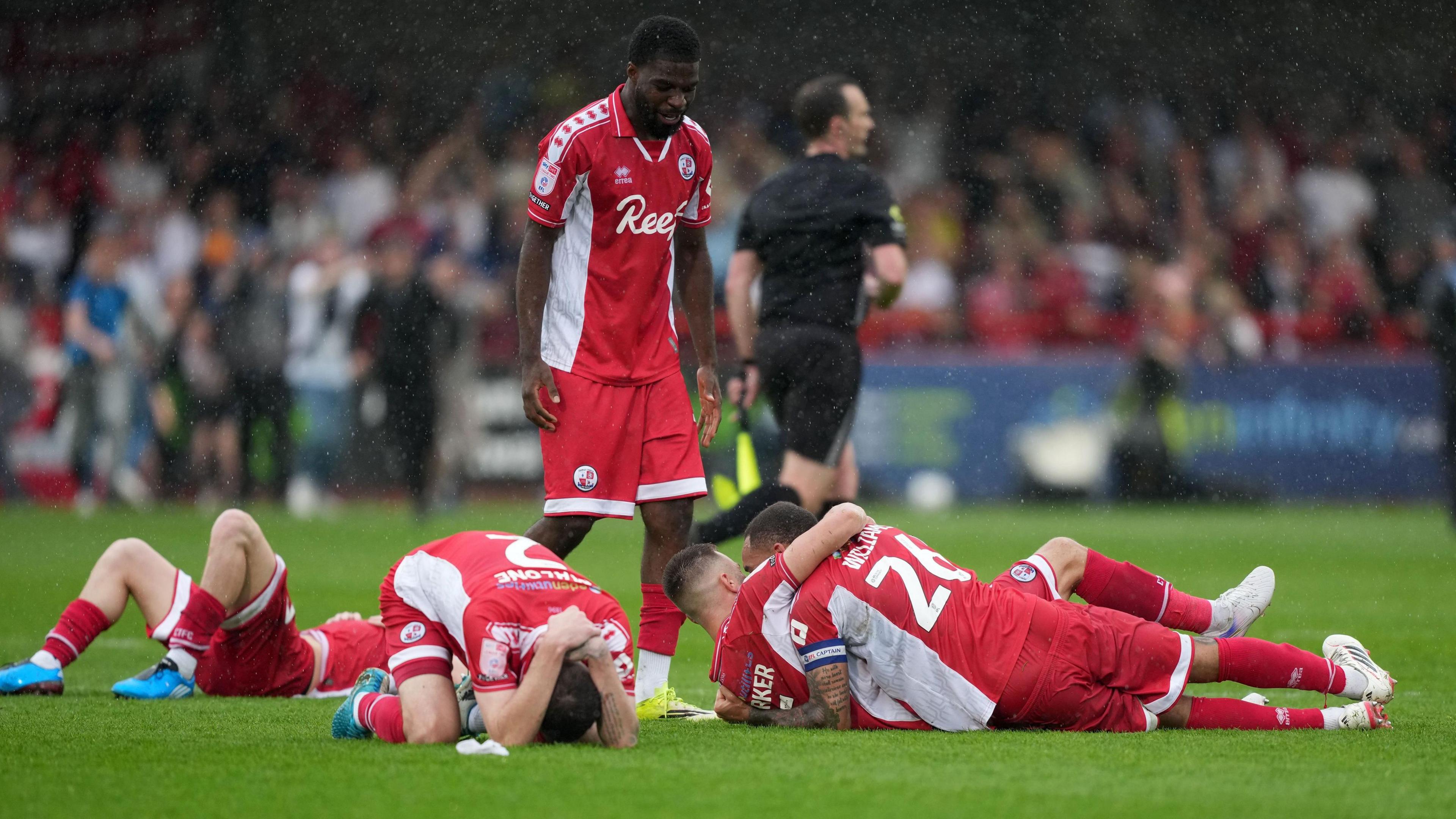 Crawley players celebrate after securing their status in the EFL