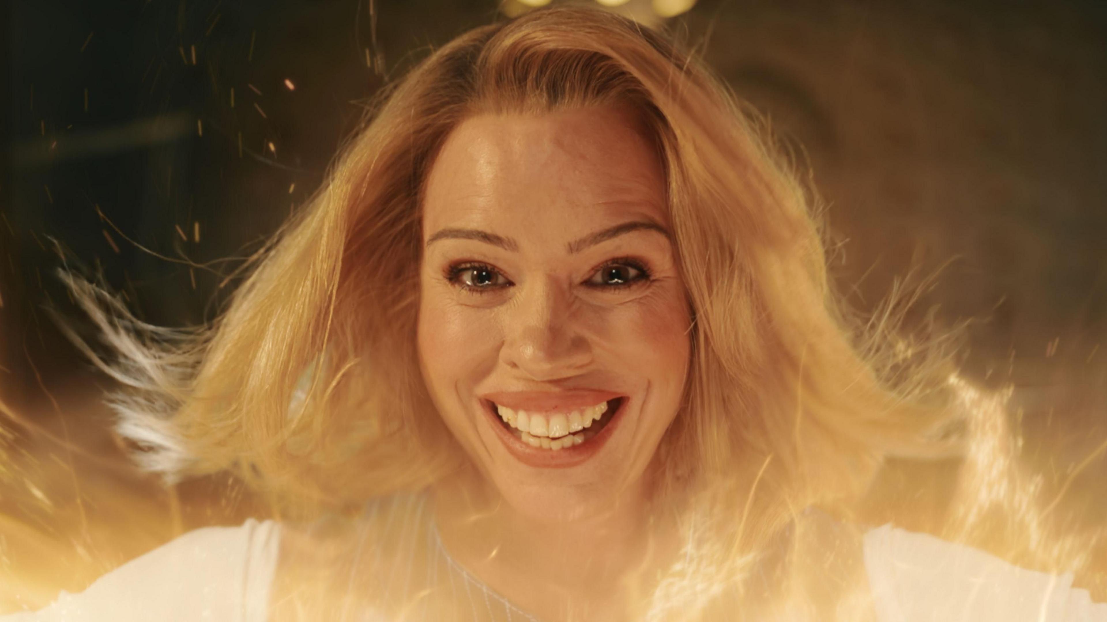 Billie Piper pictured in the final episode of Doctor Who's most recent series, smiling at the camera amidst an orange glow