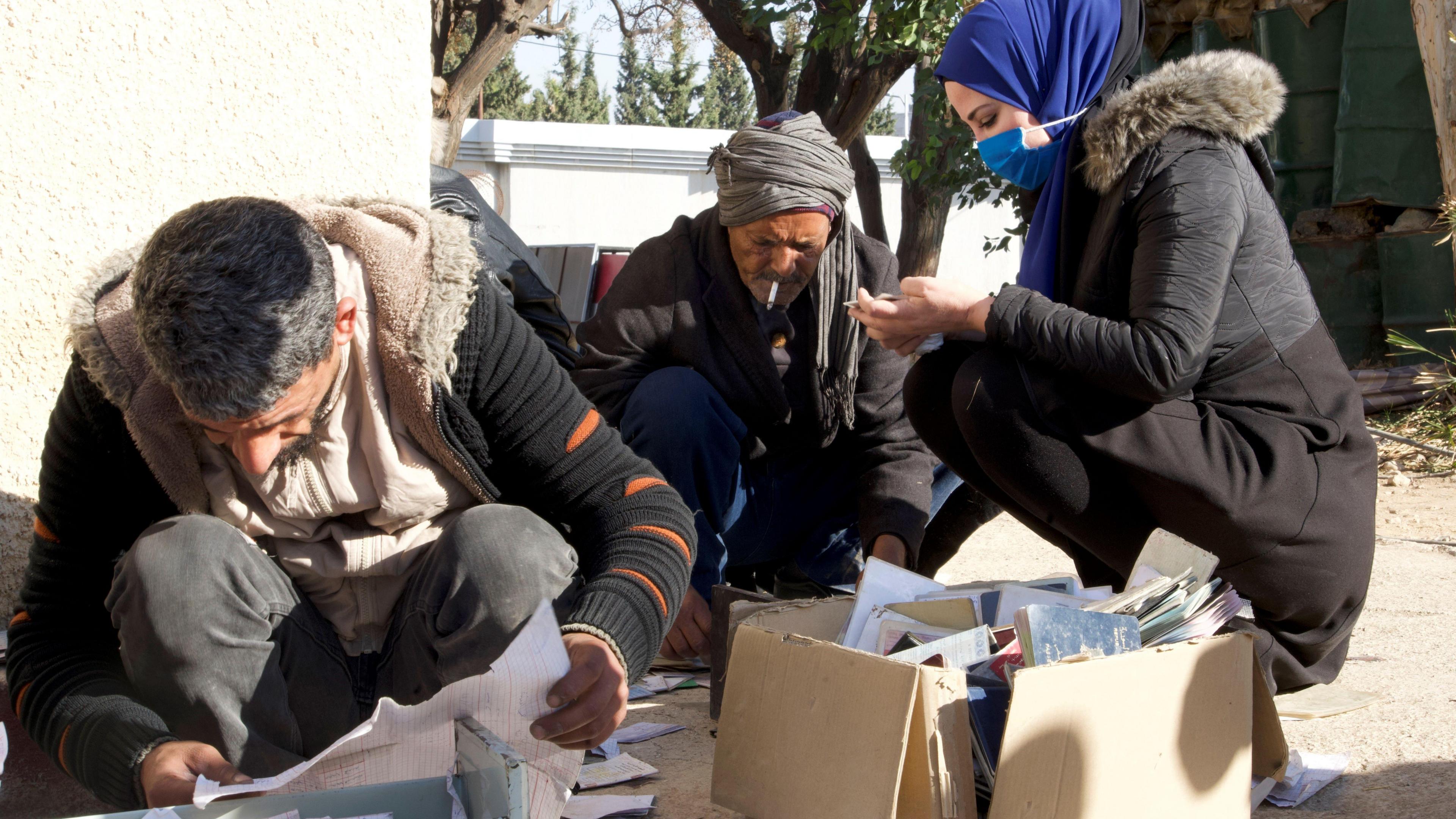 Relatives of missing people in Syria search records, passports and other documents