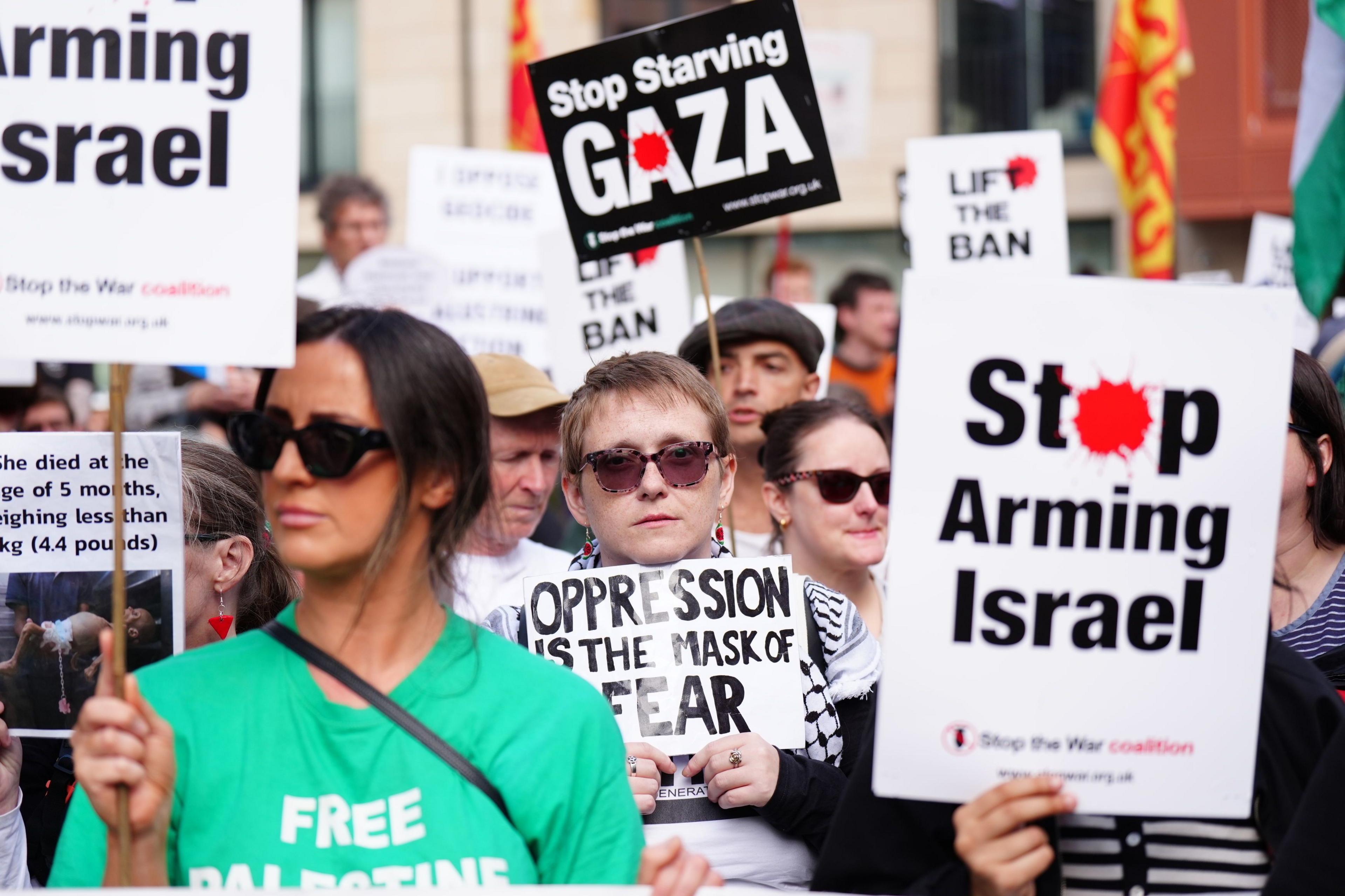 A group of demonstrators with a sign saying "Stop Arming Israel"