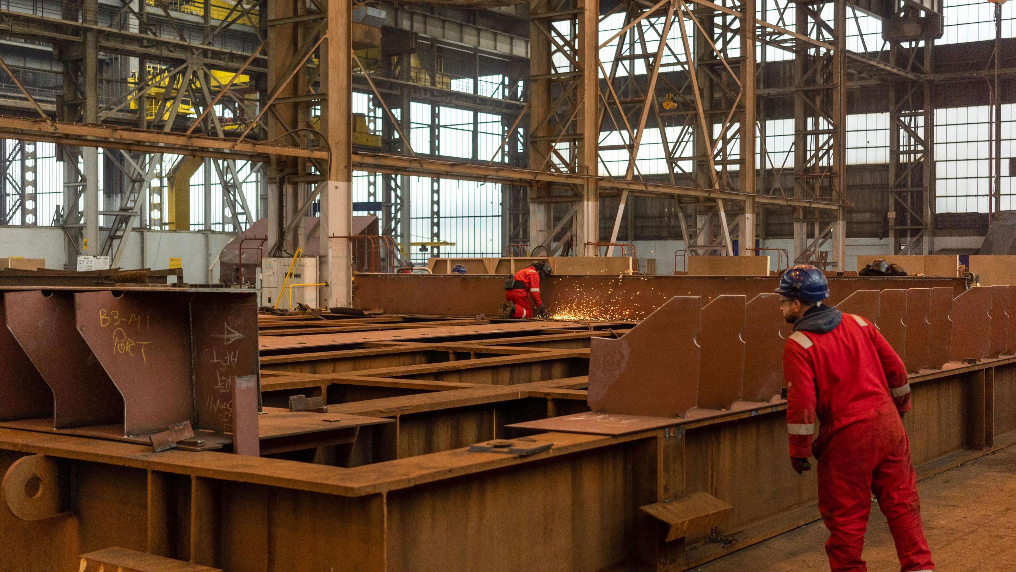 A worker grinds pieces of steel during the construction of a barge at the production facility in Harland & Wolff Group Holdings shipyard in Belfast.