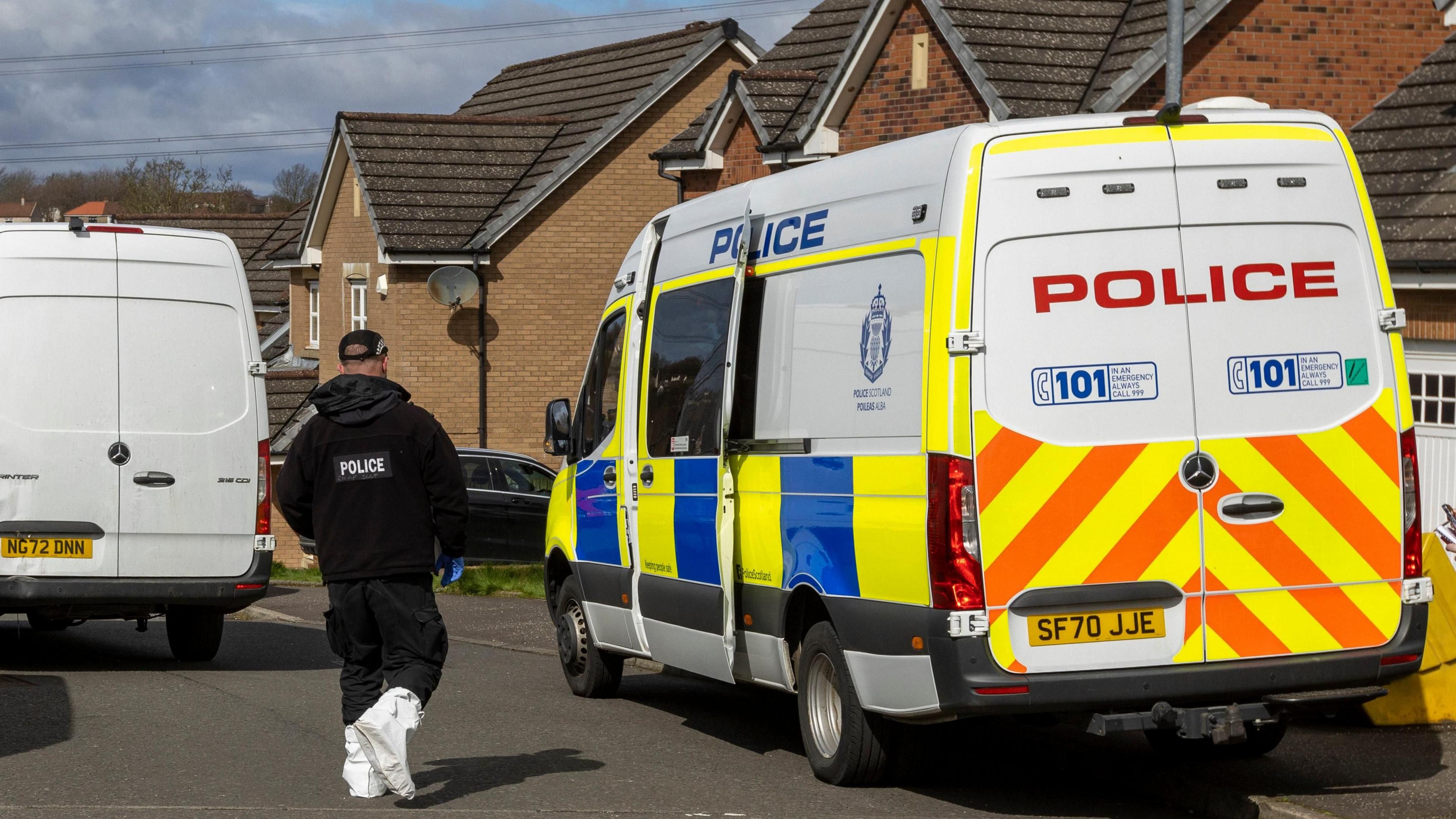 A police van and a police officer outside Murrell's home in April 2023.
