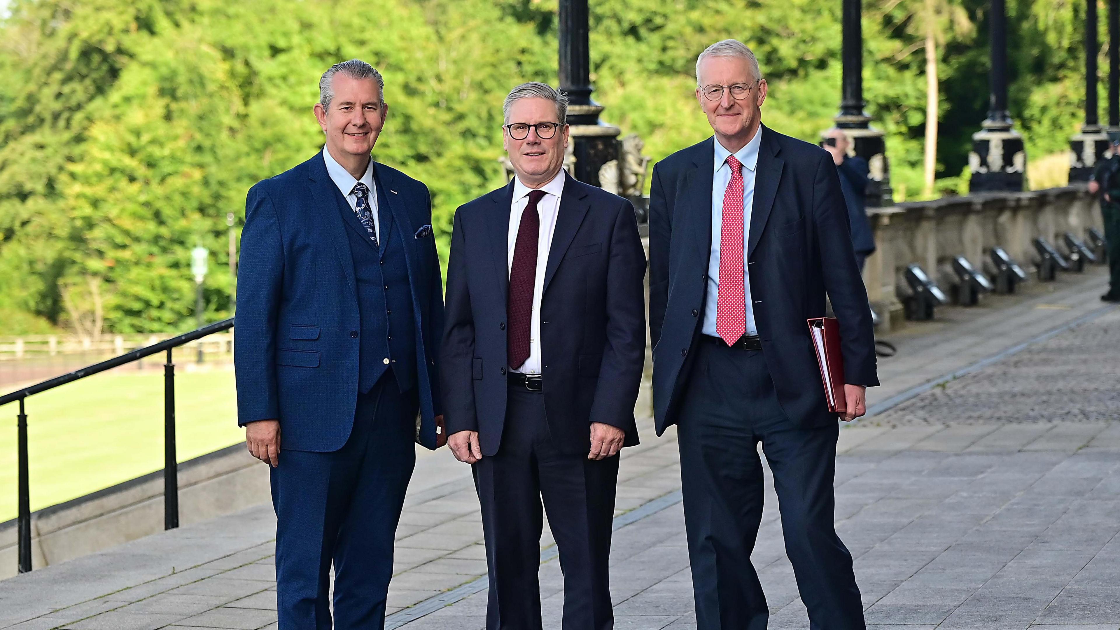 Edwin Poots, Sir Keir Starmer and Hilary Benn - Three men in suits stand at the top of the steps of Stormont