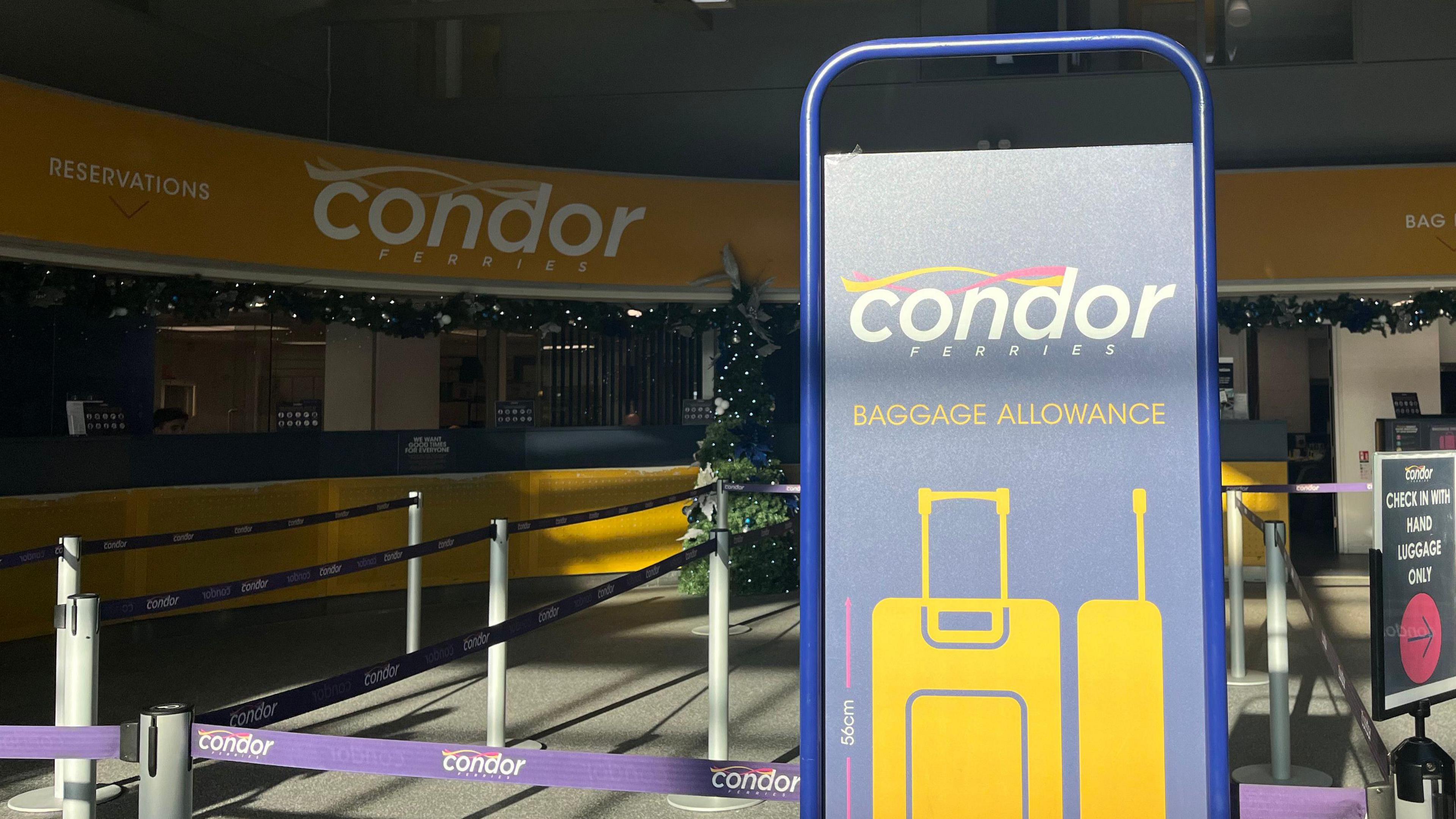 Condor Ferries check in desk behind with a Condor Ferries baggage allowance checker in front.