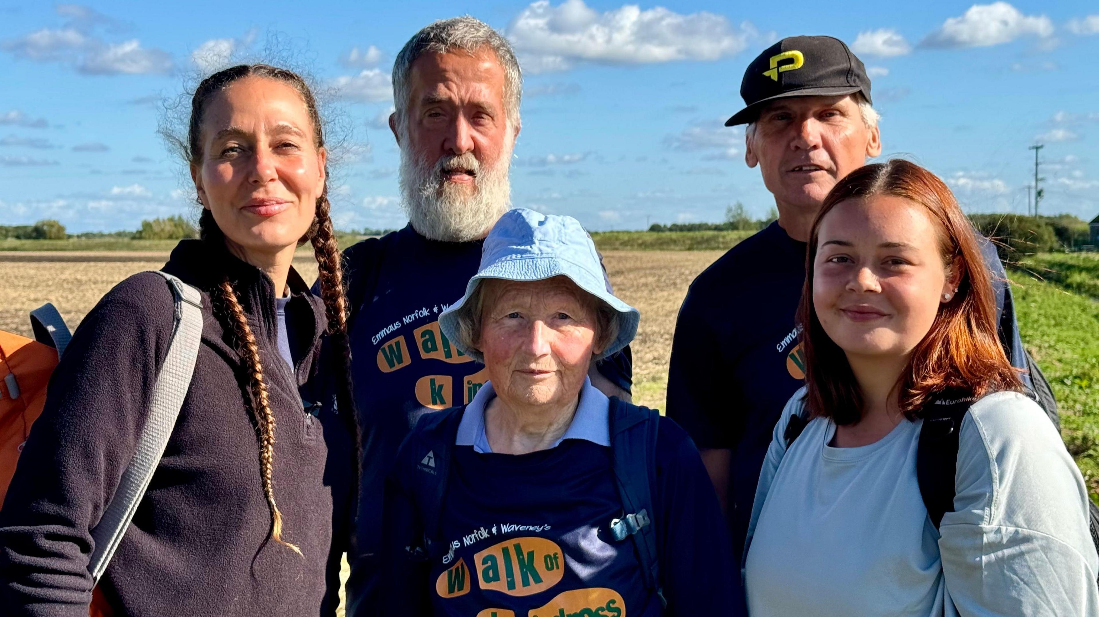 Cecile Roberts (left) wearing a black fleece and is carrying an orange back pack. She is stood with two men and two women who are taking part in the charity walk. 