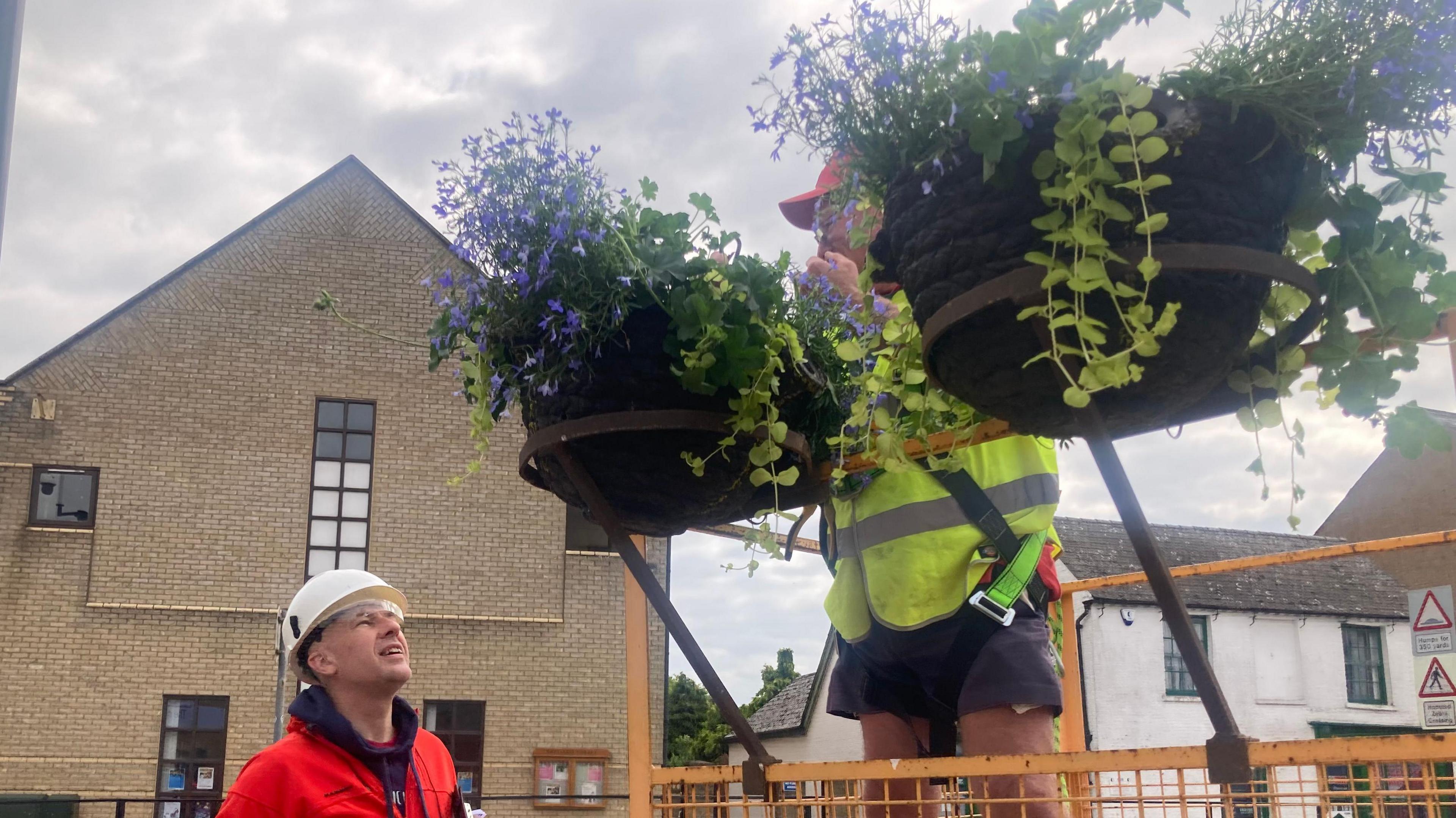 Hanging baskets being put up.