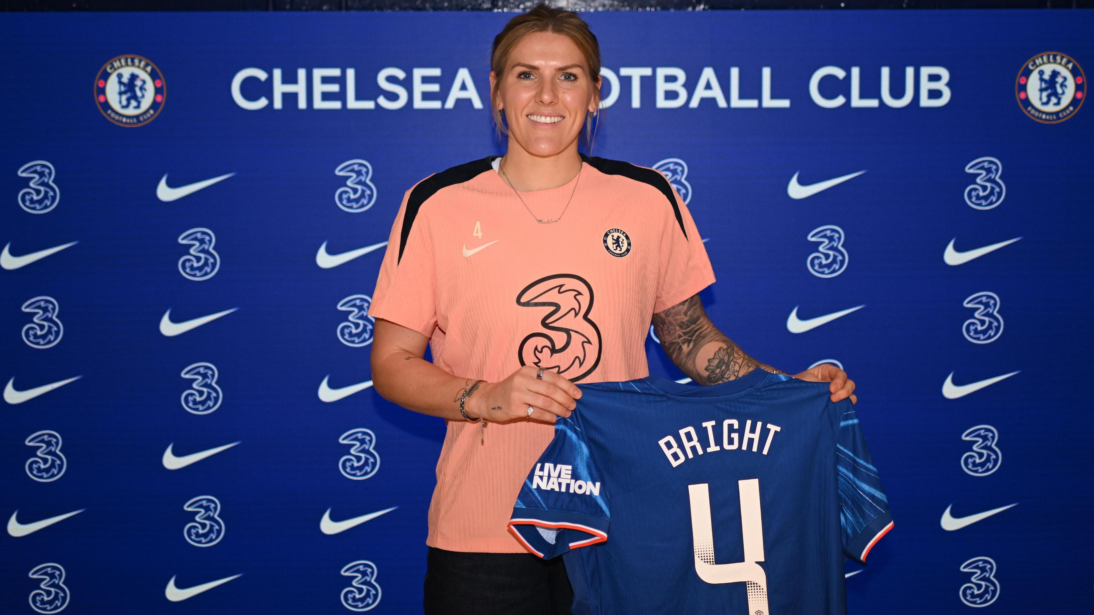 Millie Bright holds a Chelsea shirt with her name on the back