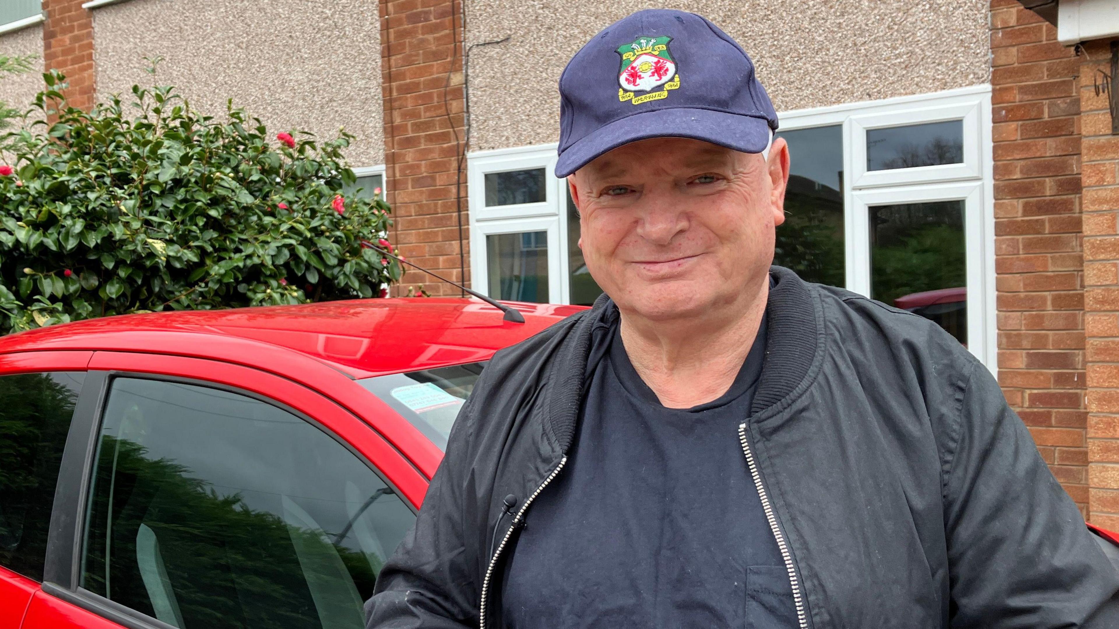 Driving instructor, Stuart Walker leaning against his car