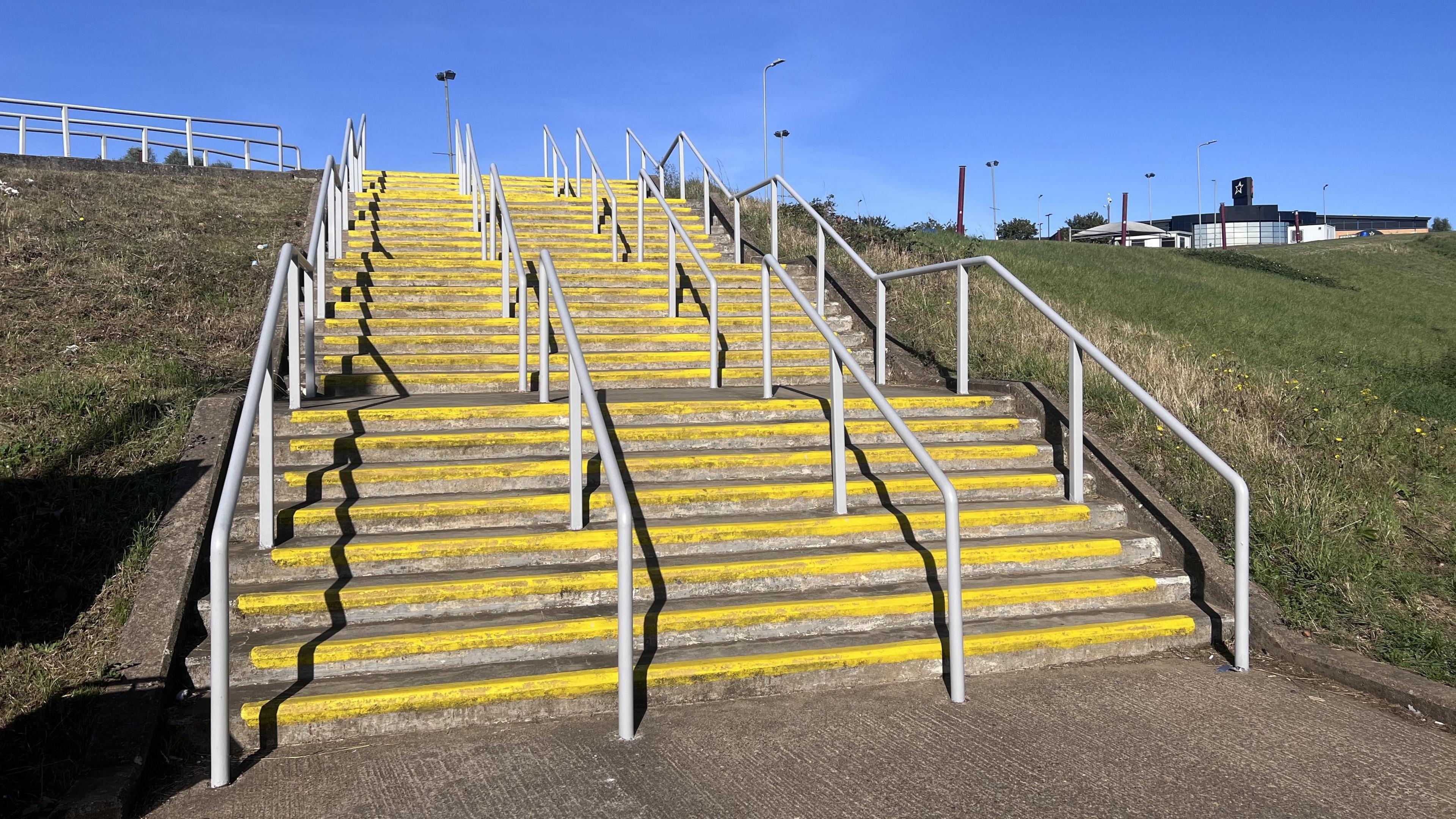 A flight of yellow-lined steps with white handrails at Sixfields Stadium in Northampton