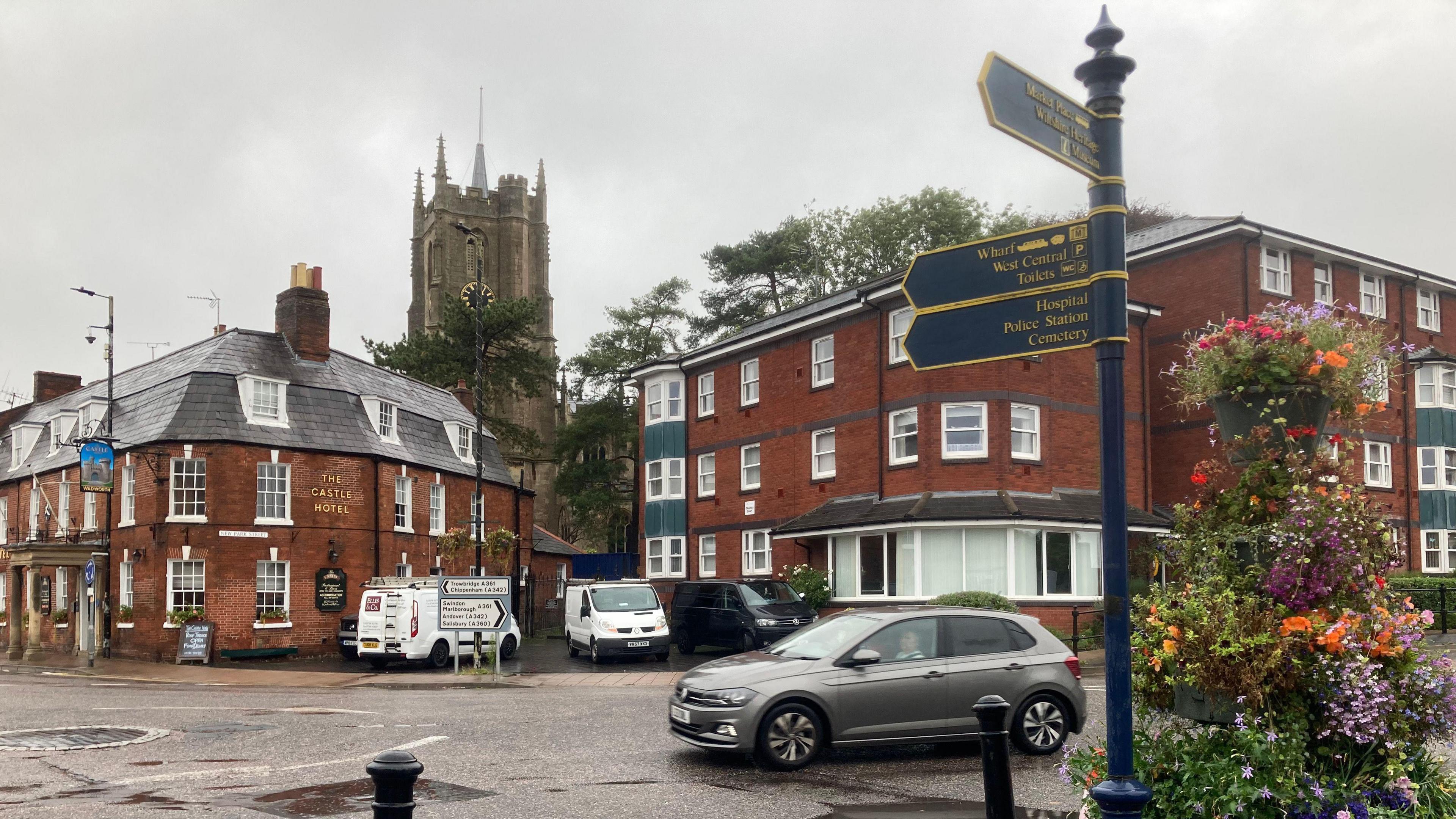 Image with a signpost, with a view of Castle Hotel and the cathedral in the background