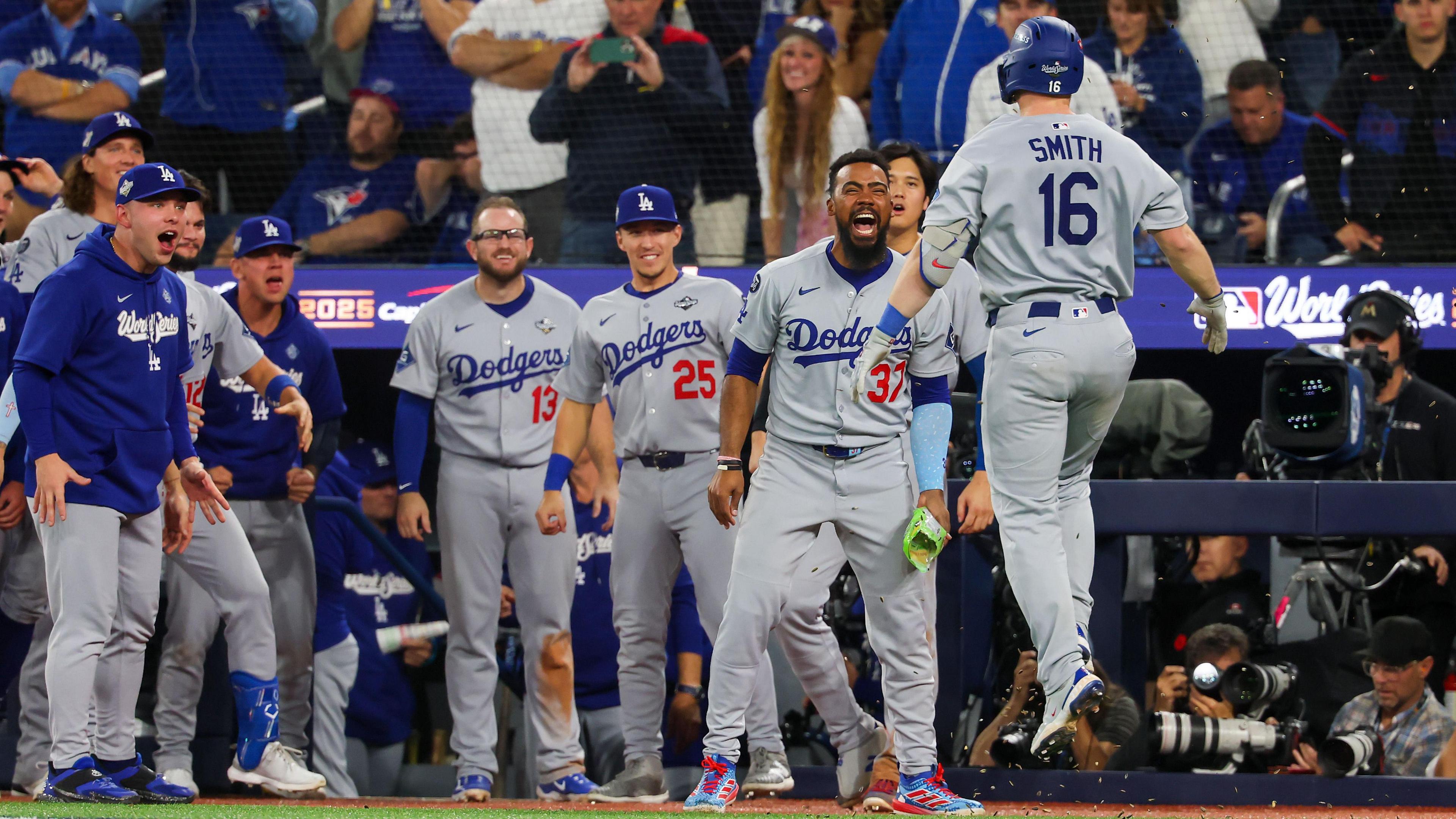 The Los Angeles Dodgers players celebrate as Will Smith (right) reaches home plate after his 11th-inning home run