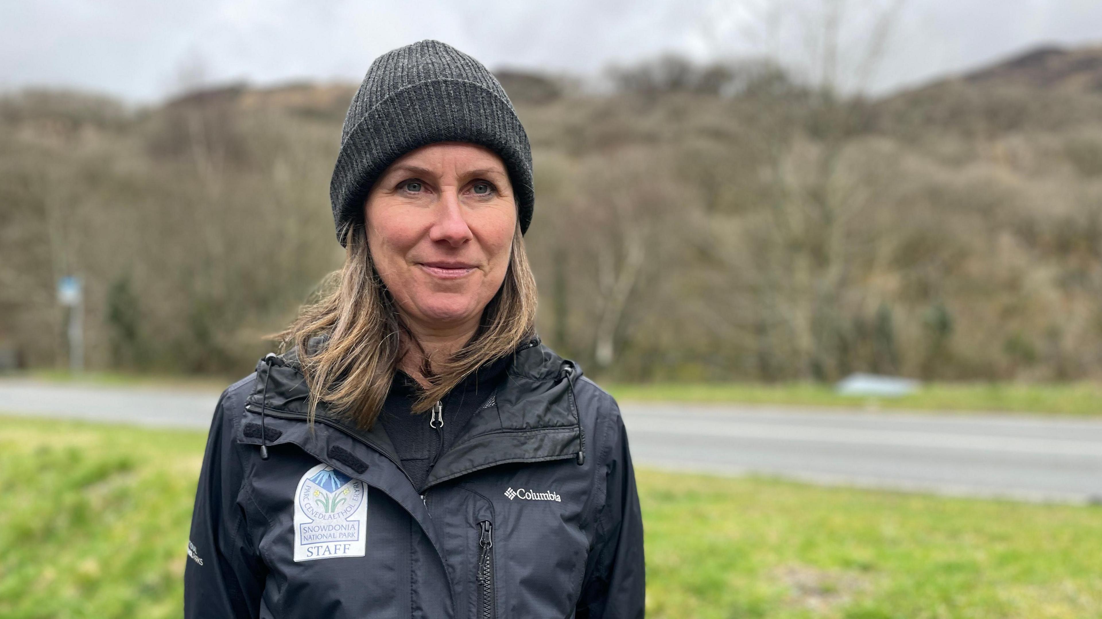 Angela Jones from Eryri National Park stood in Nant Gwynant wearing hat a dark waterproof