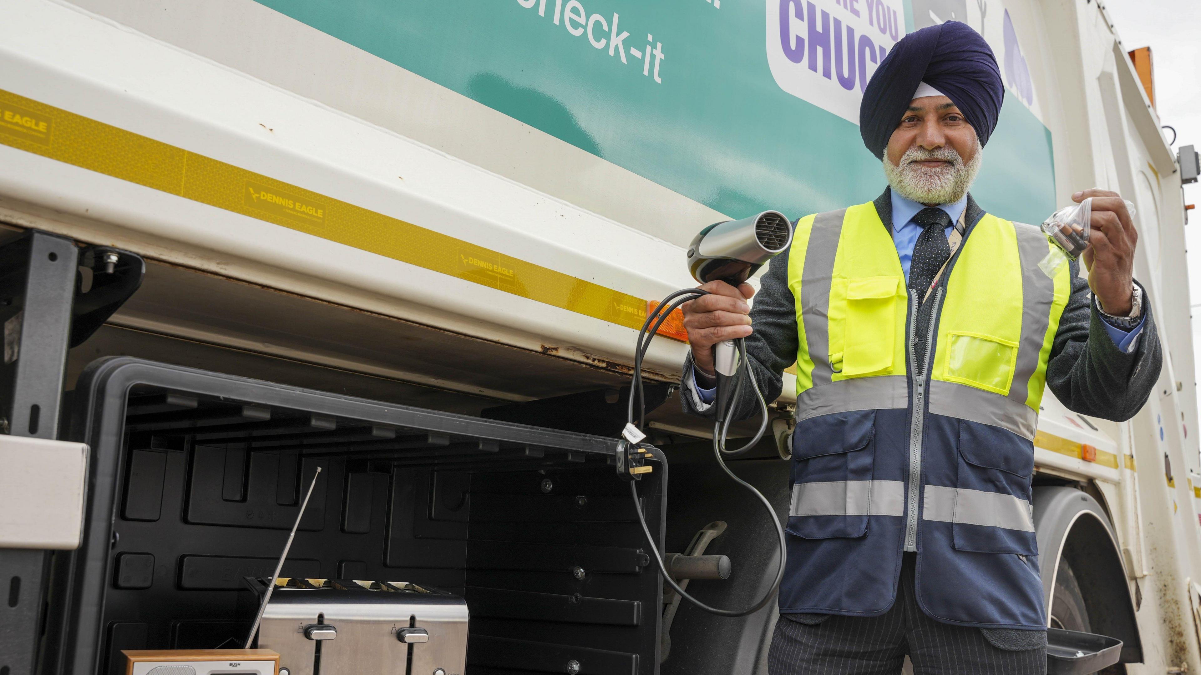 Councillor Bhupinder Gakhal, cabinet member for resident services, with some examples of small electricals that can be collected, including a radio, toaster, hairdryer and bag of household batteries