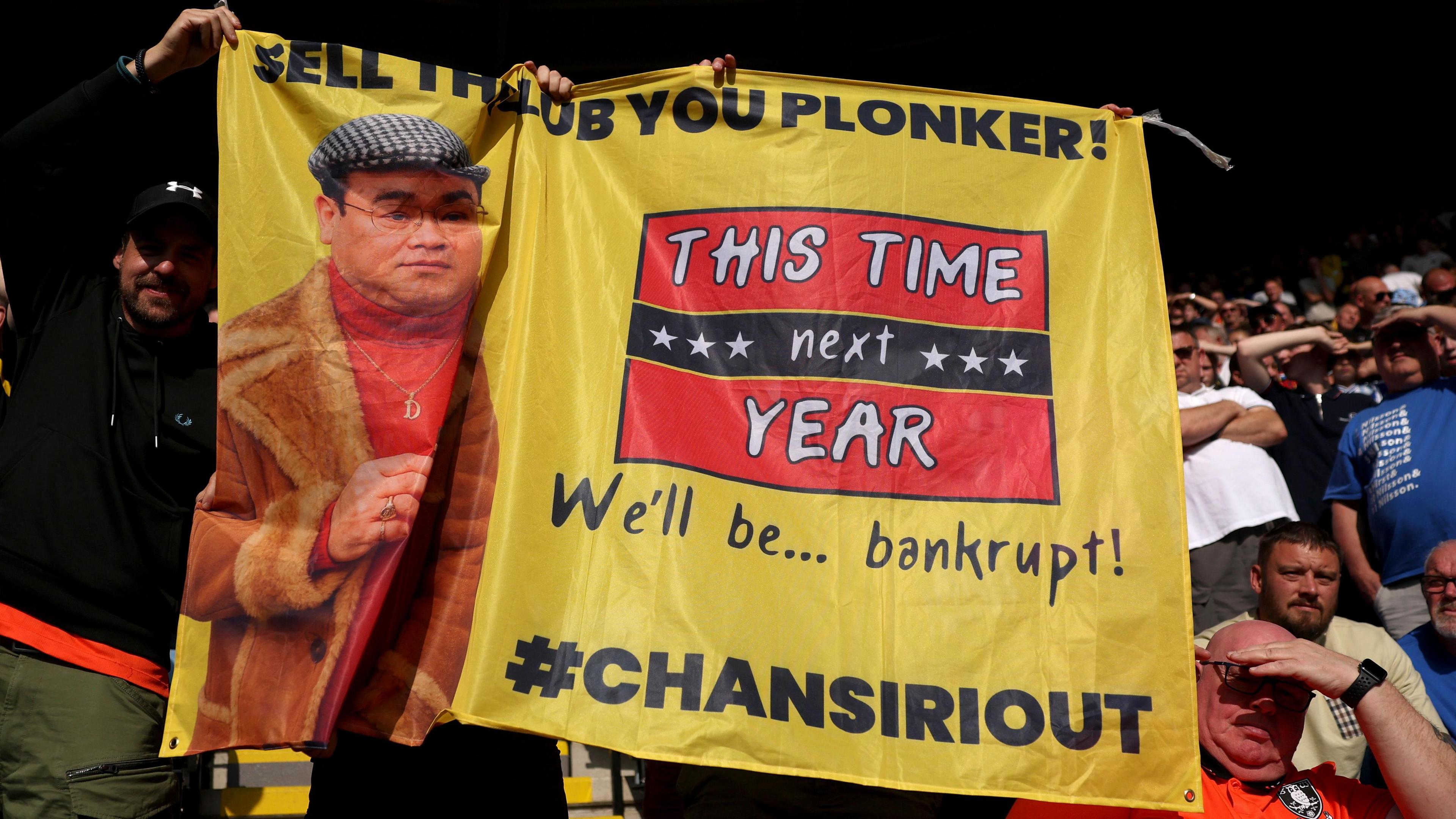 A Sheffield Wednesday fan holding up a Only Fool and Horses themed protest banner against club owner Dejphon Chansiri at their opening Championship game against Leicester City