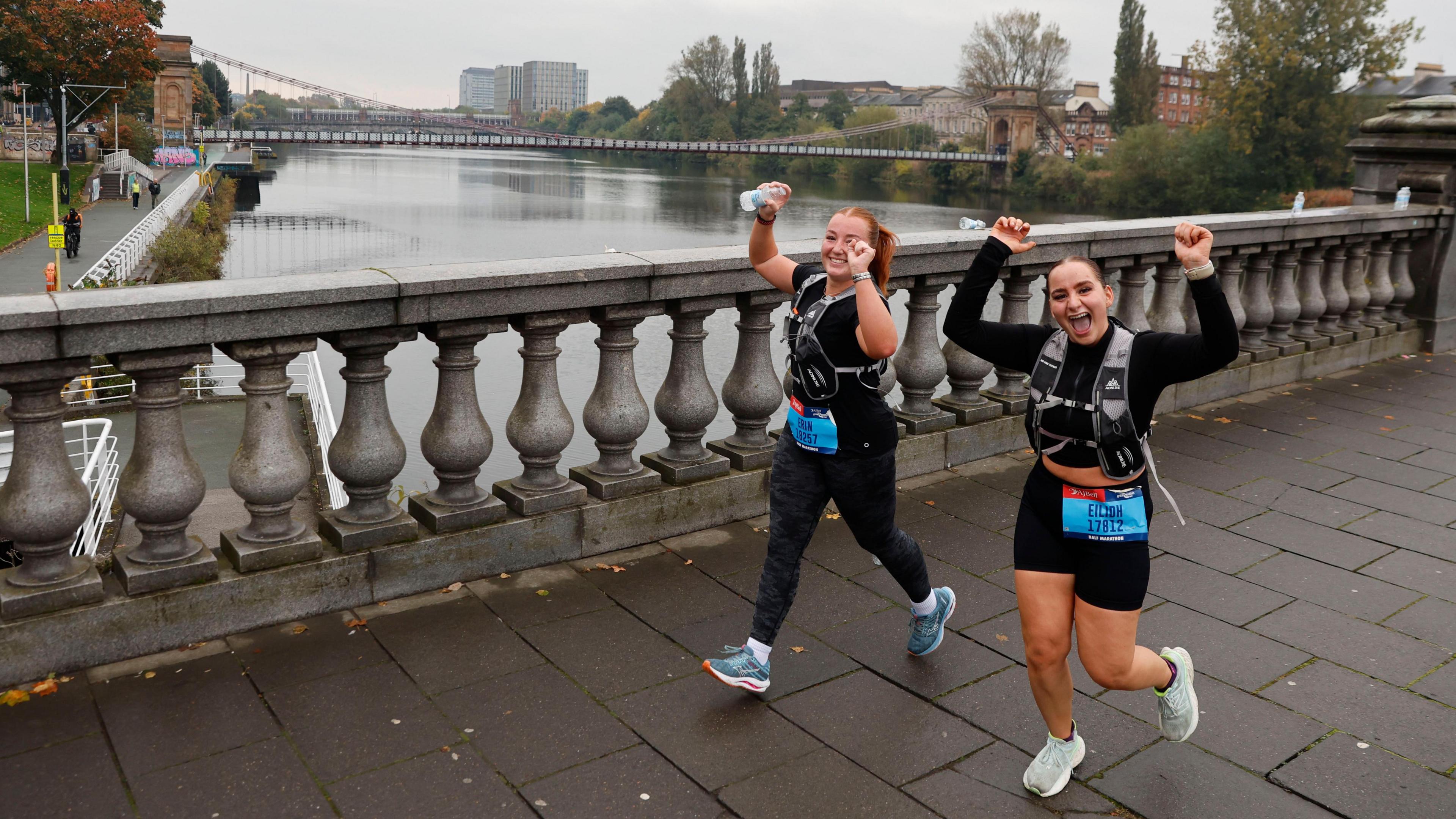 Two females runners going over a bridge in Glasgow