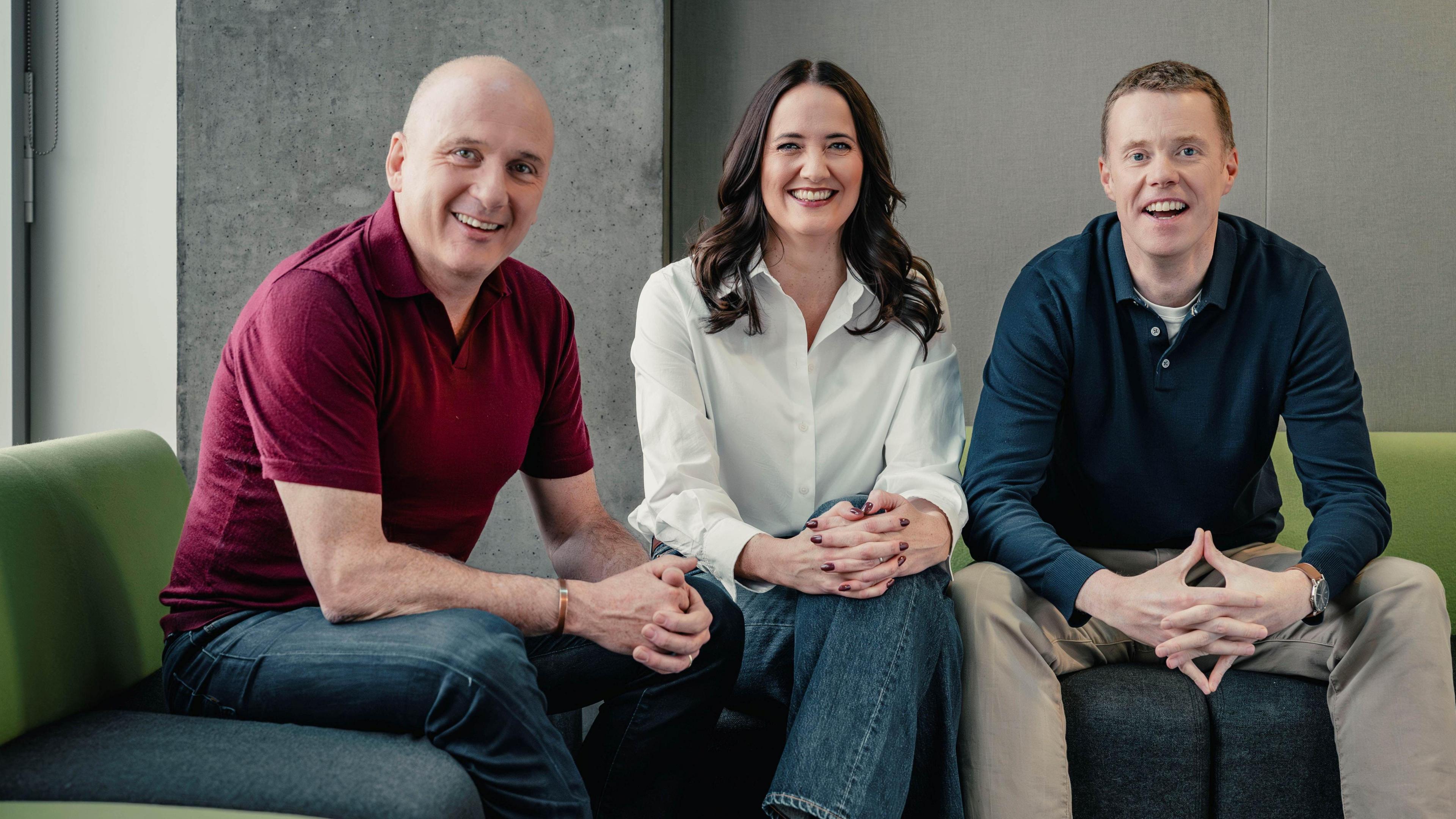 Martin Geissler, Laura Maciver and Phil Goodlad sitting on green sofas. They are all casually dressed.