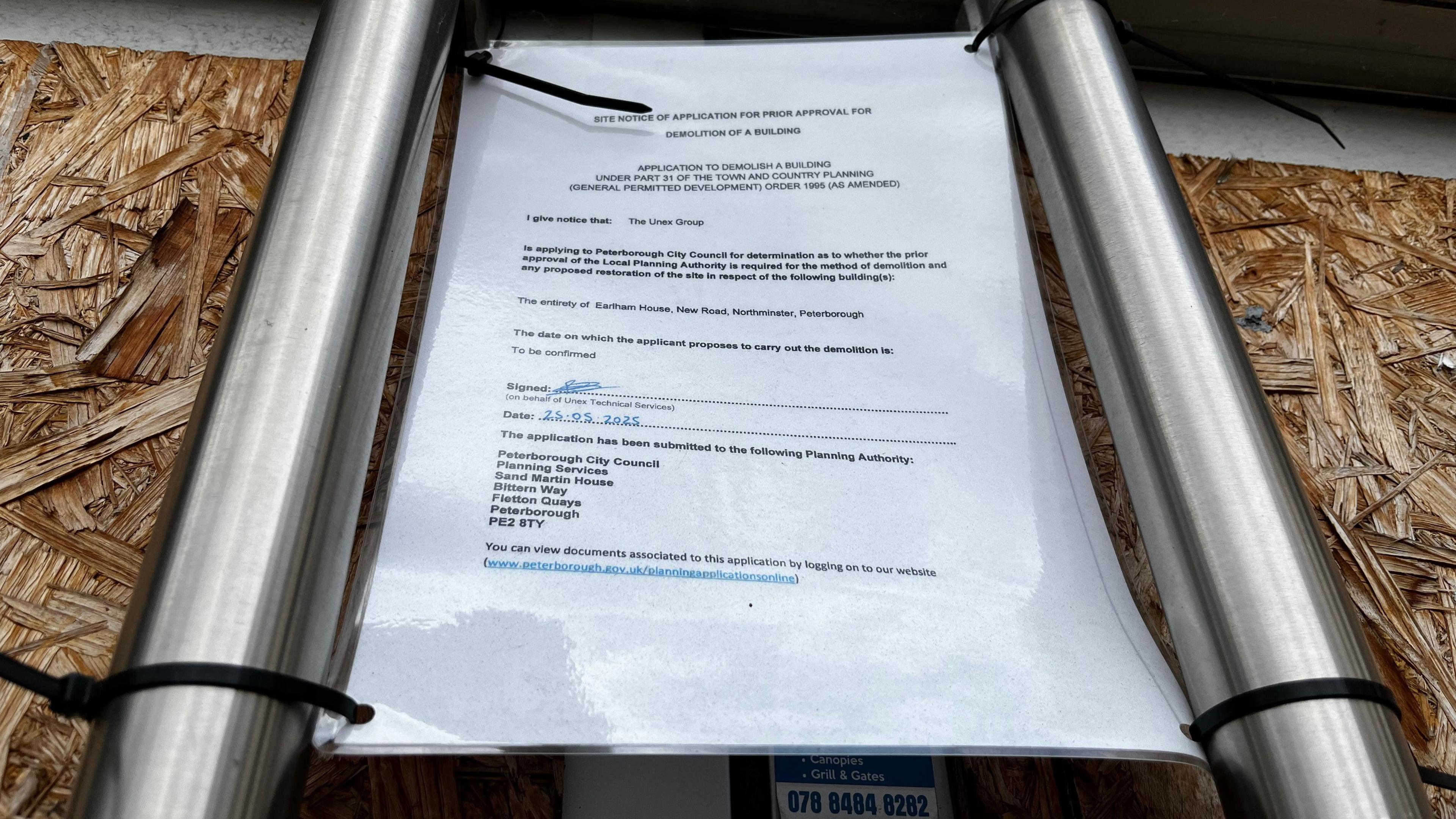 A laminated notice attached to the door of a former nightclub door showing how it is required for demolition.