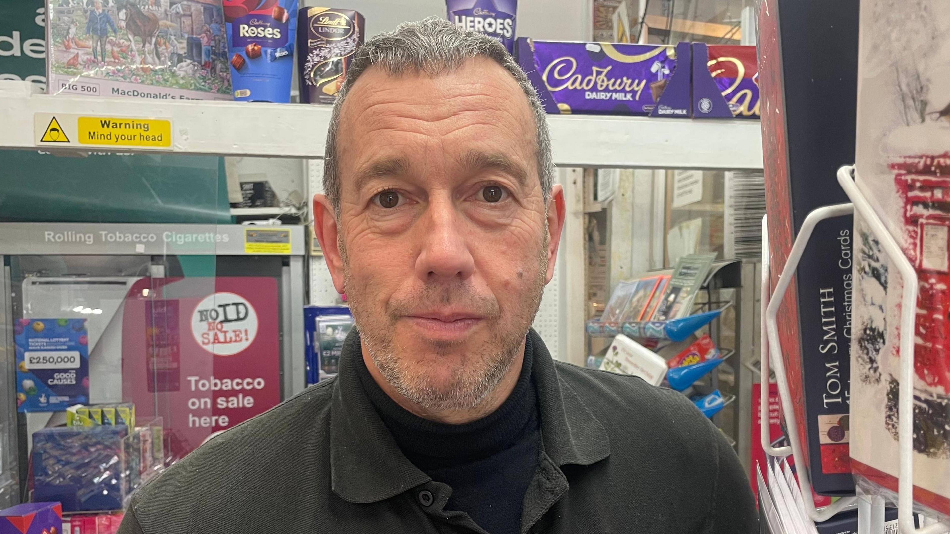 Sub-postmaster David Ward smiles inside East Barkwith Post Office
