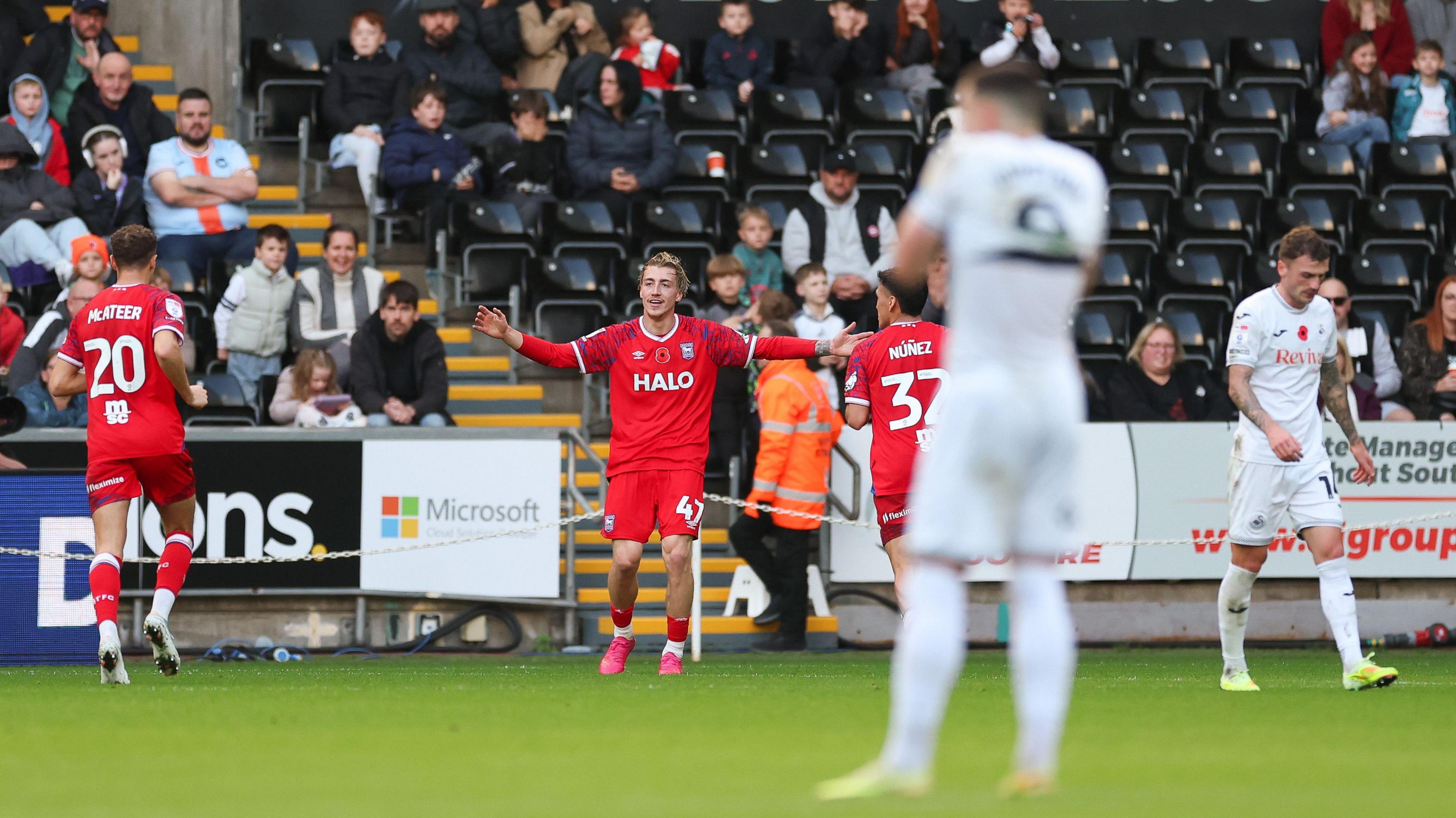 Swansea players look dejected as Jack Clarke celebrates scoring for Ipswich 