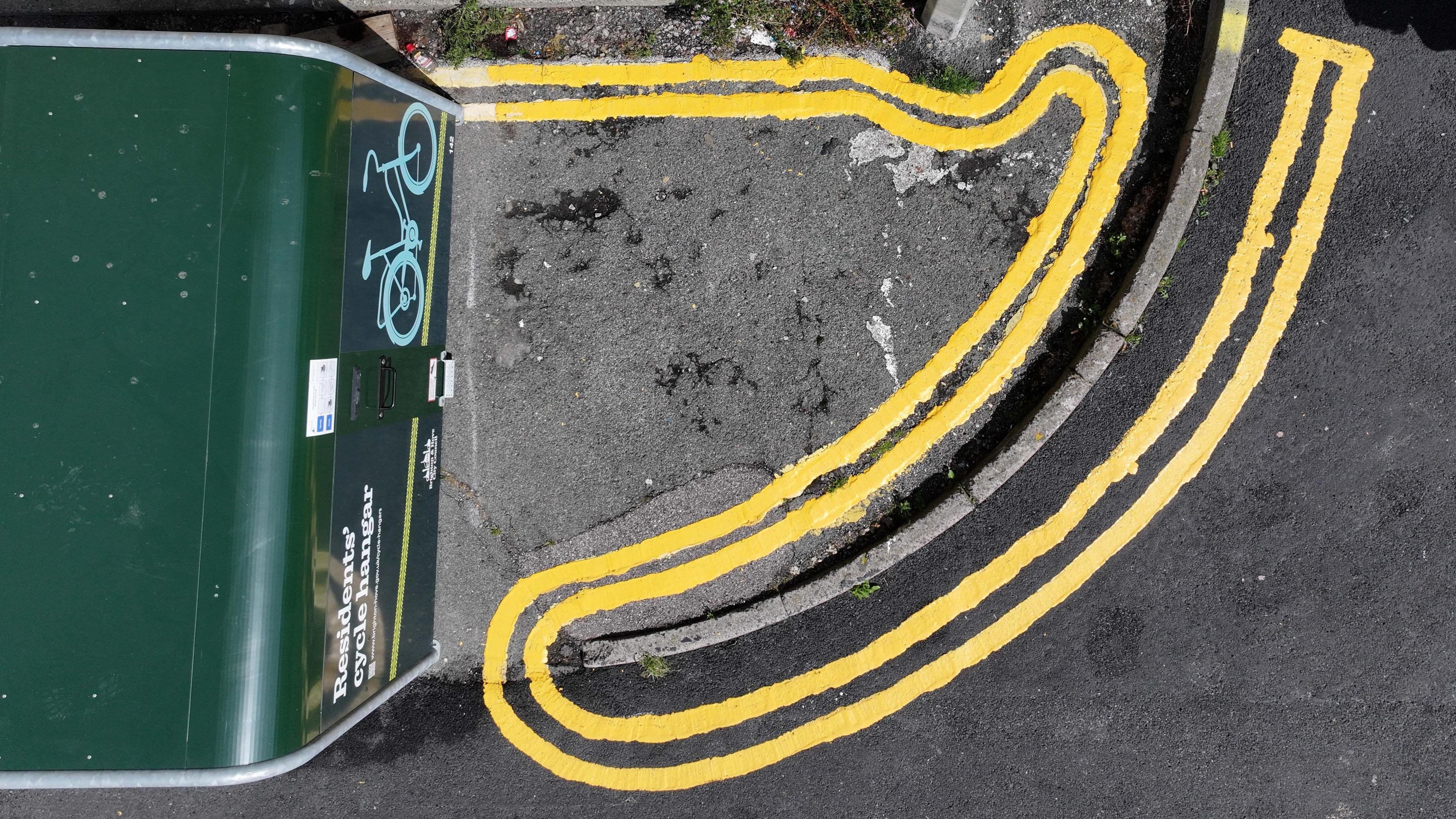 An aerial shot of freshly painted double lines that loop back on themselves around a curb