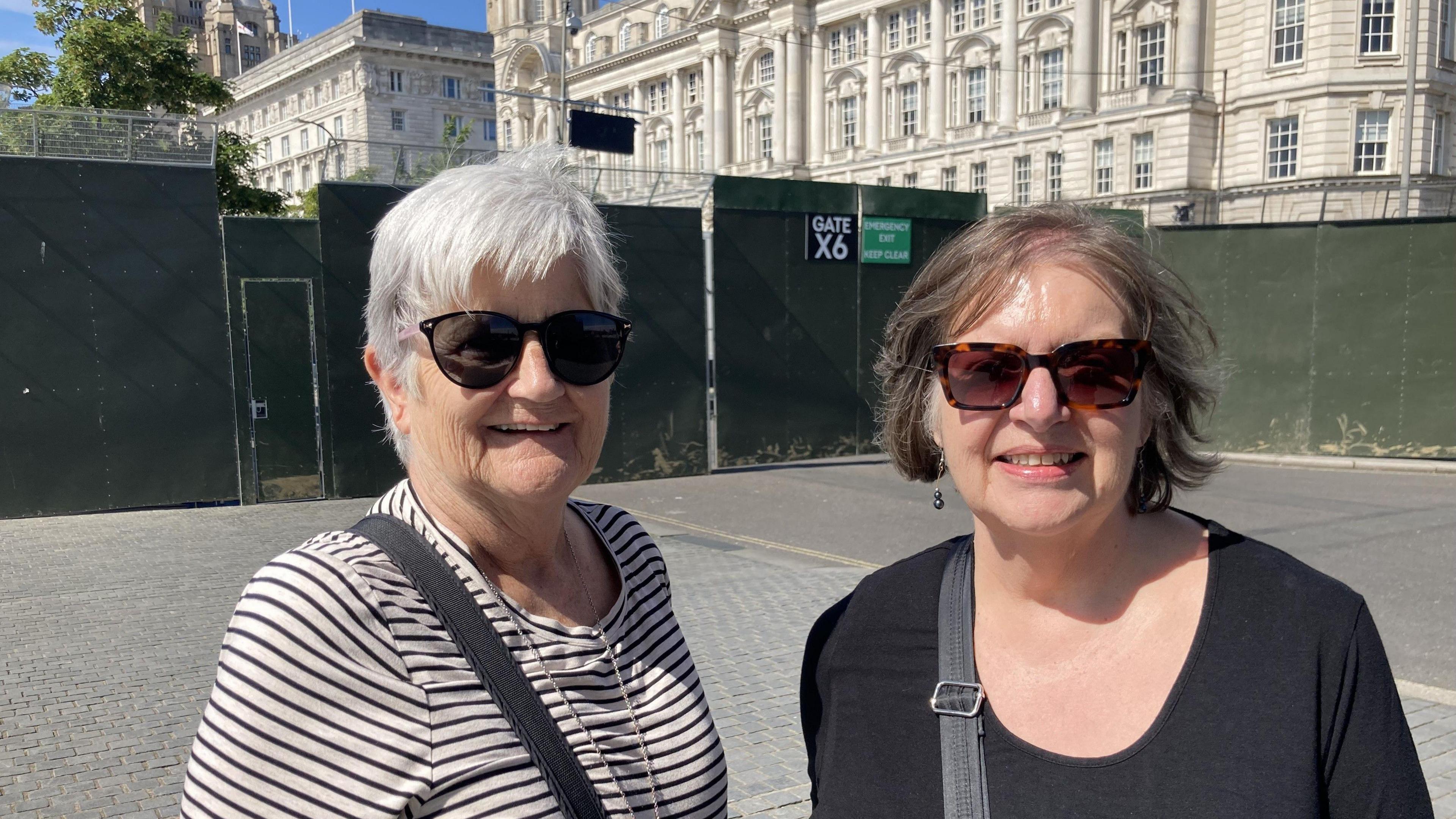 Tourists Carol and Diane at the Pier Head in front of high security fencing