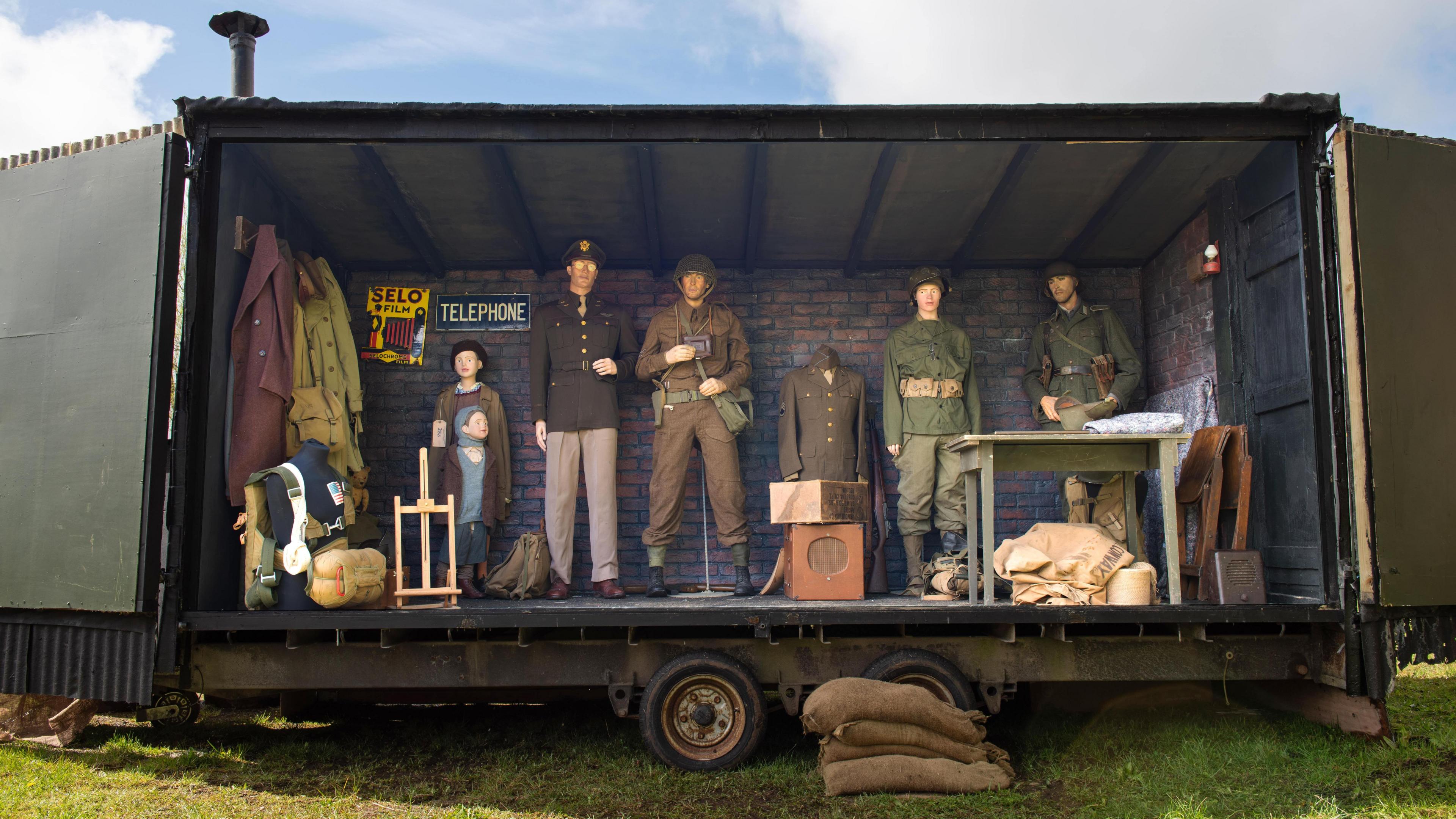 The mobile museum opens up on one side to exhibit a range of World War Two memorabilia. There are five war uniforms and two child sized models clothed.