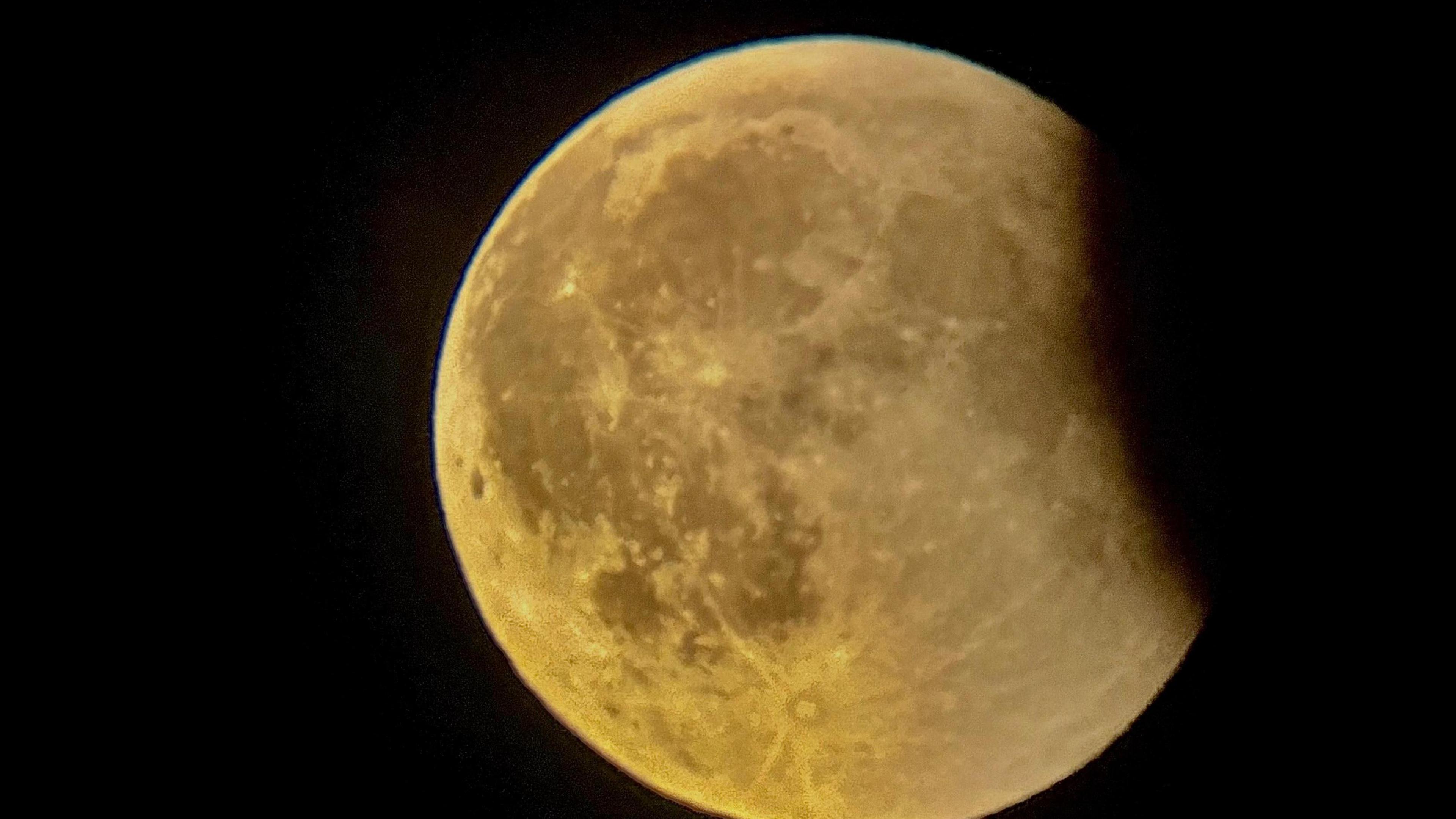 An image of the Moon captured during the lunar eclipse on 7 September, with the Moon appearing to take on a yellow hue.
