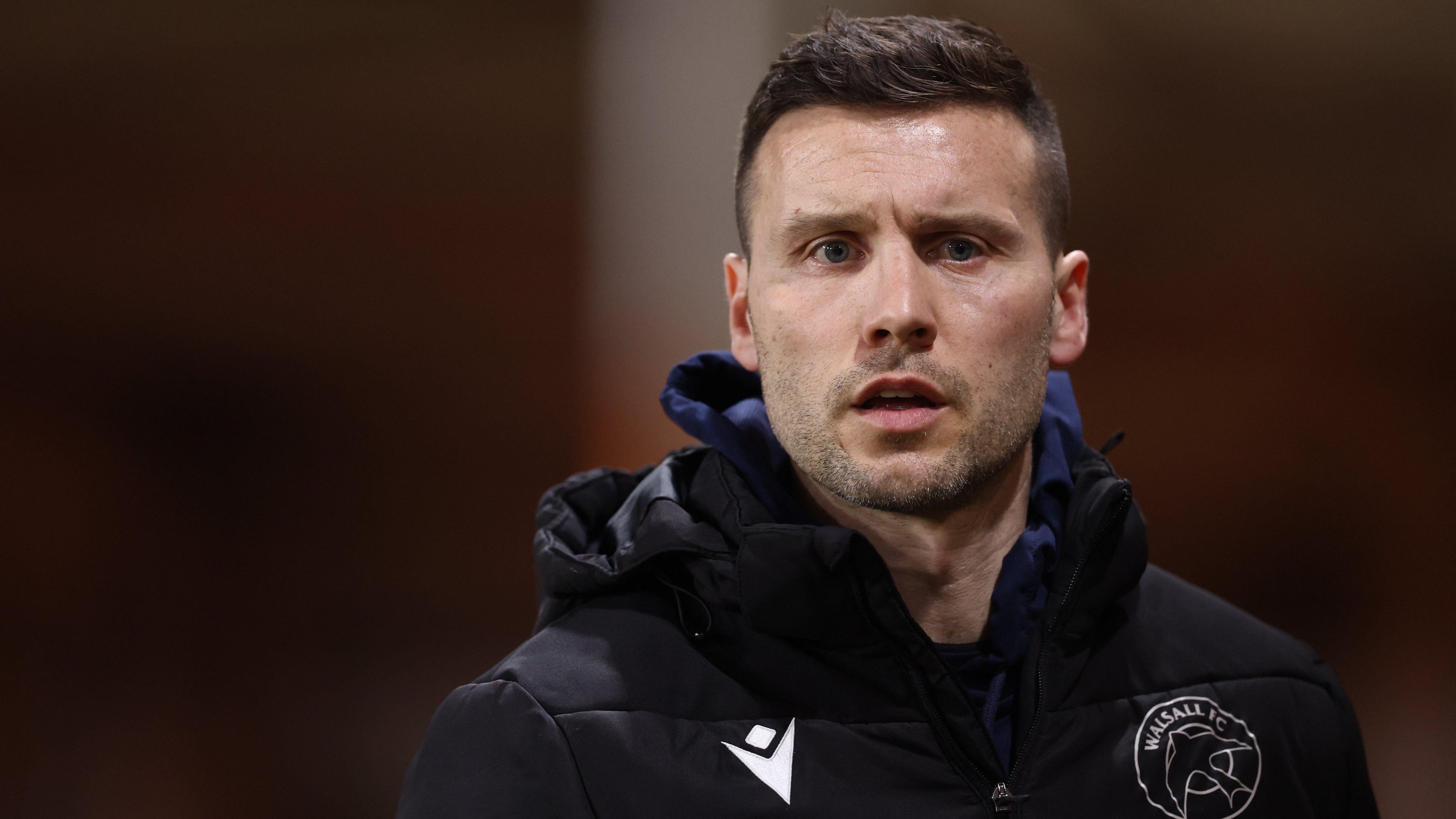 Walsall head coach Mat Sadler walks along the touchline 