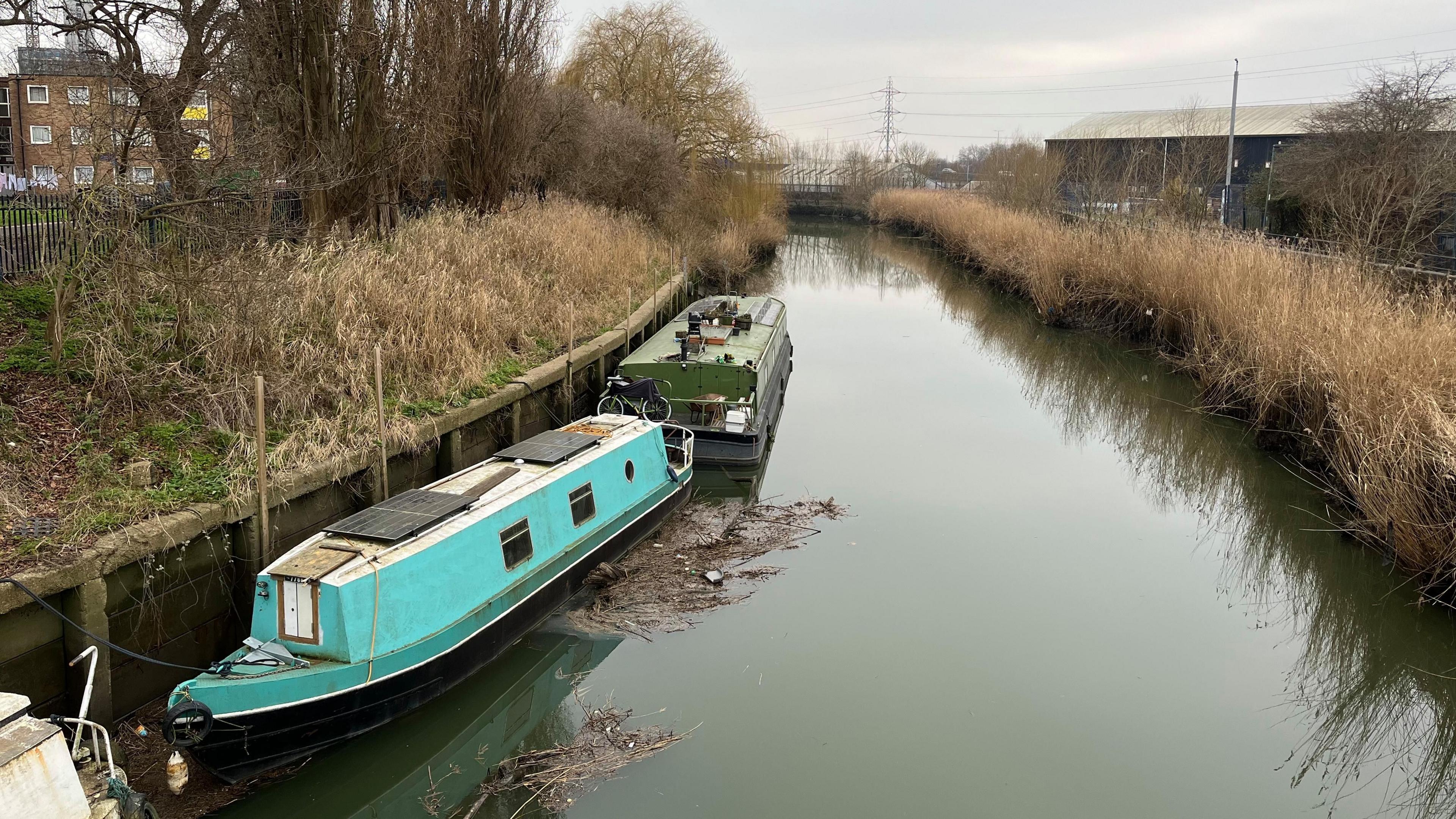 Two long boats rest on a river