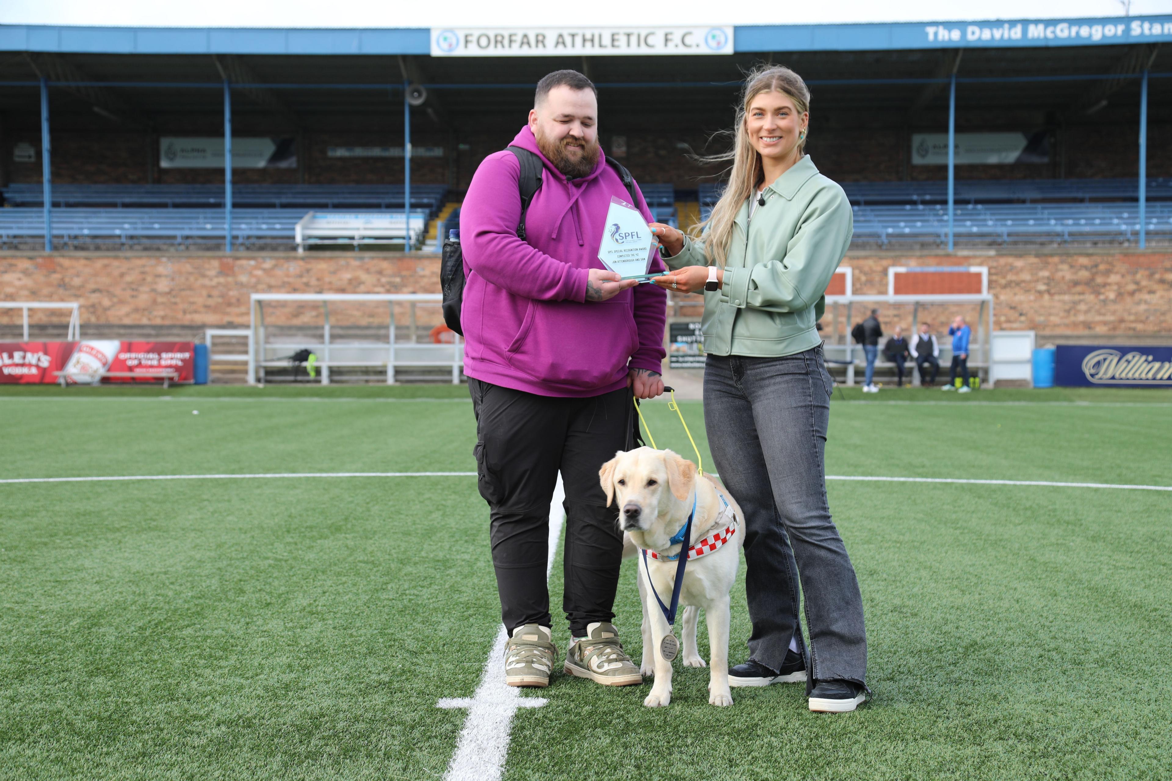 Jon Attenborough labrador Sam receive an award from the SPFL to mark their achievement