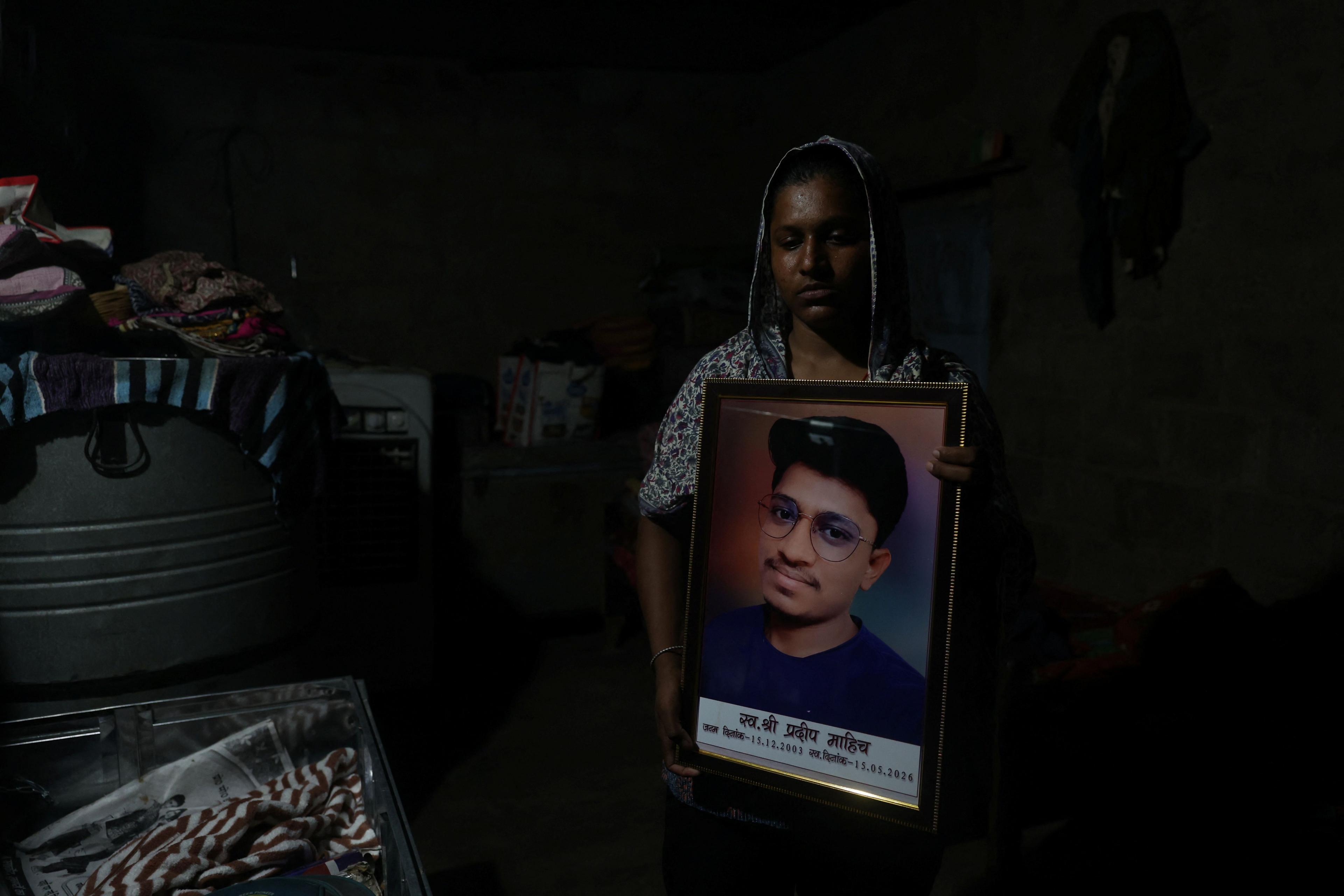 Babita Kumari, sister of Pradeep Kumar, 22, an aspirant doctor who took his own life after the results of the first NEET exam were cancelled, poses for a picture as she holds a photo of her brother at her home in Jhunjhunu, India, July 21, 2026. REUTERS/Francis Mascarenhas