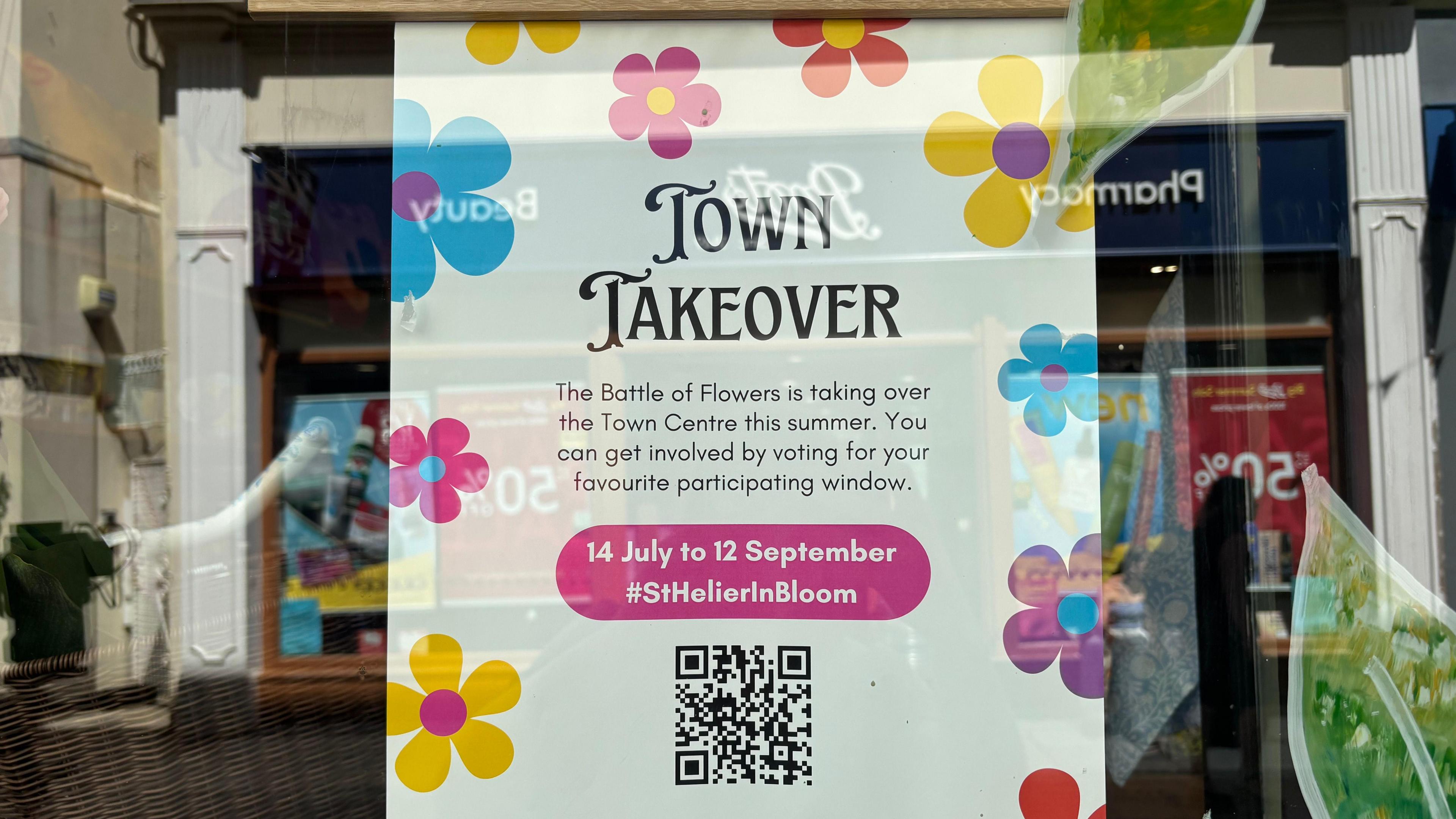 A 'Town Takeover' poster in a shop window.
