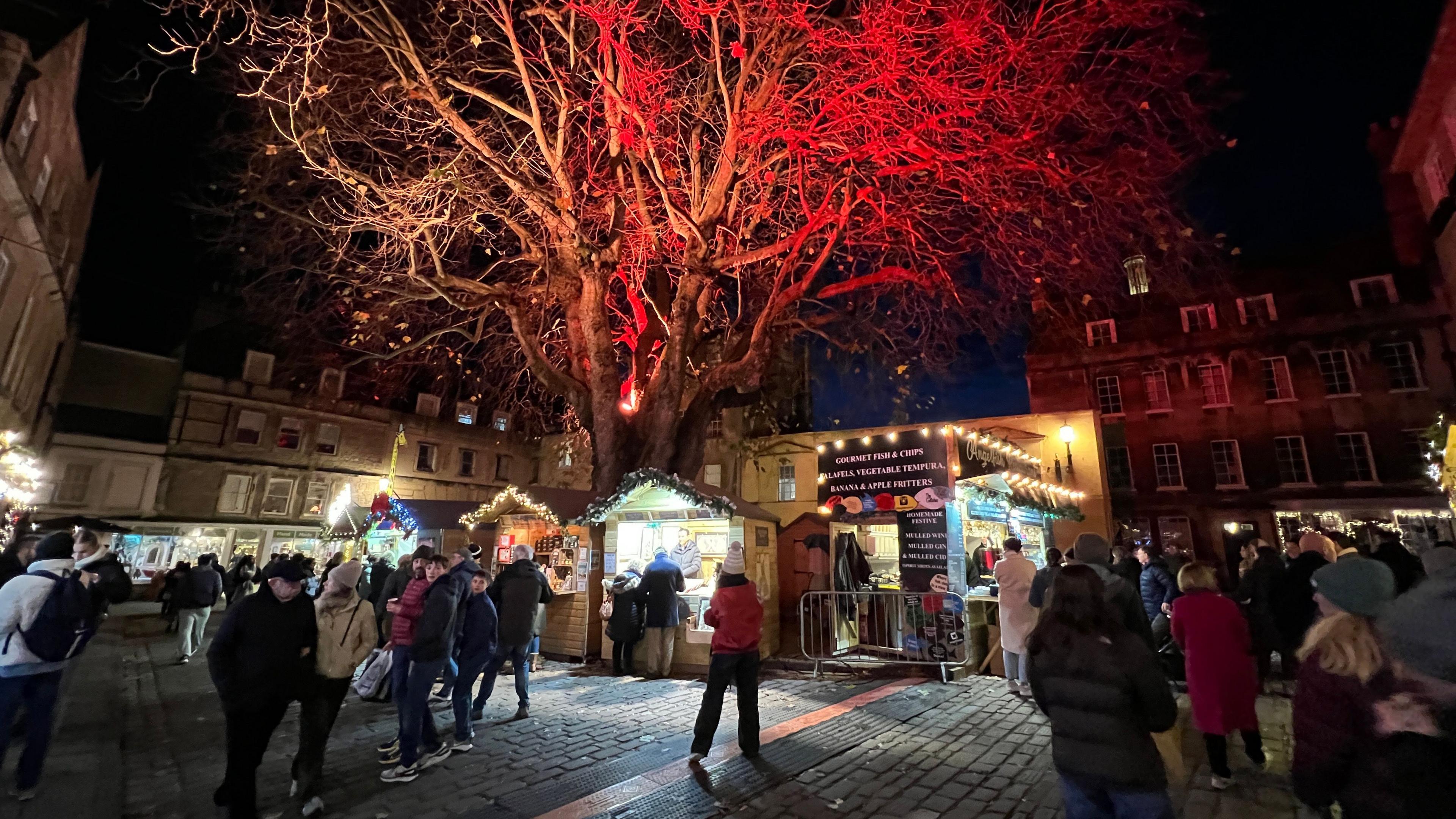 People walking through Bath Christmas Market at night