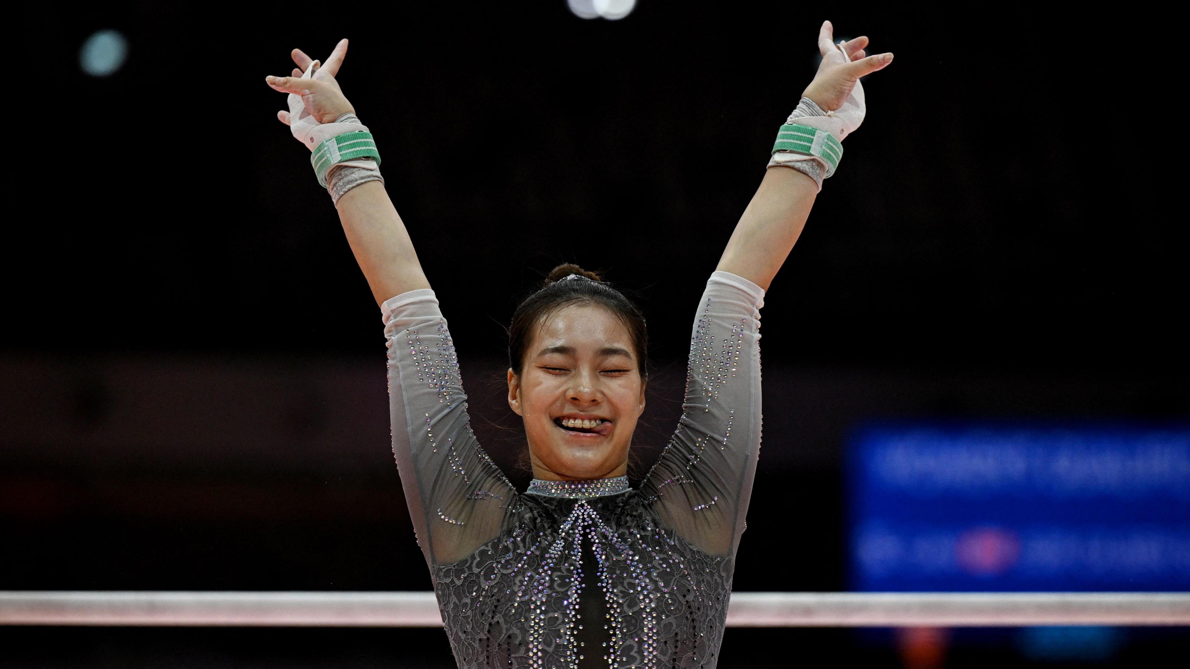 South Korea's Yunseo Lee reacts during her uneven bars exercise