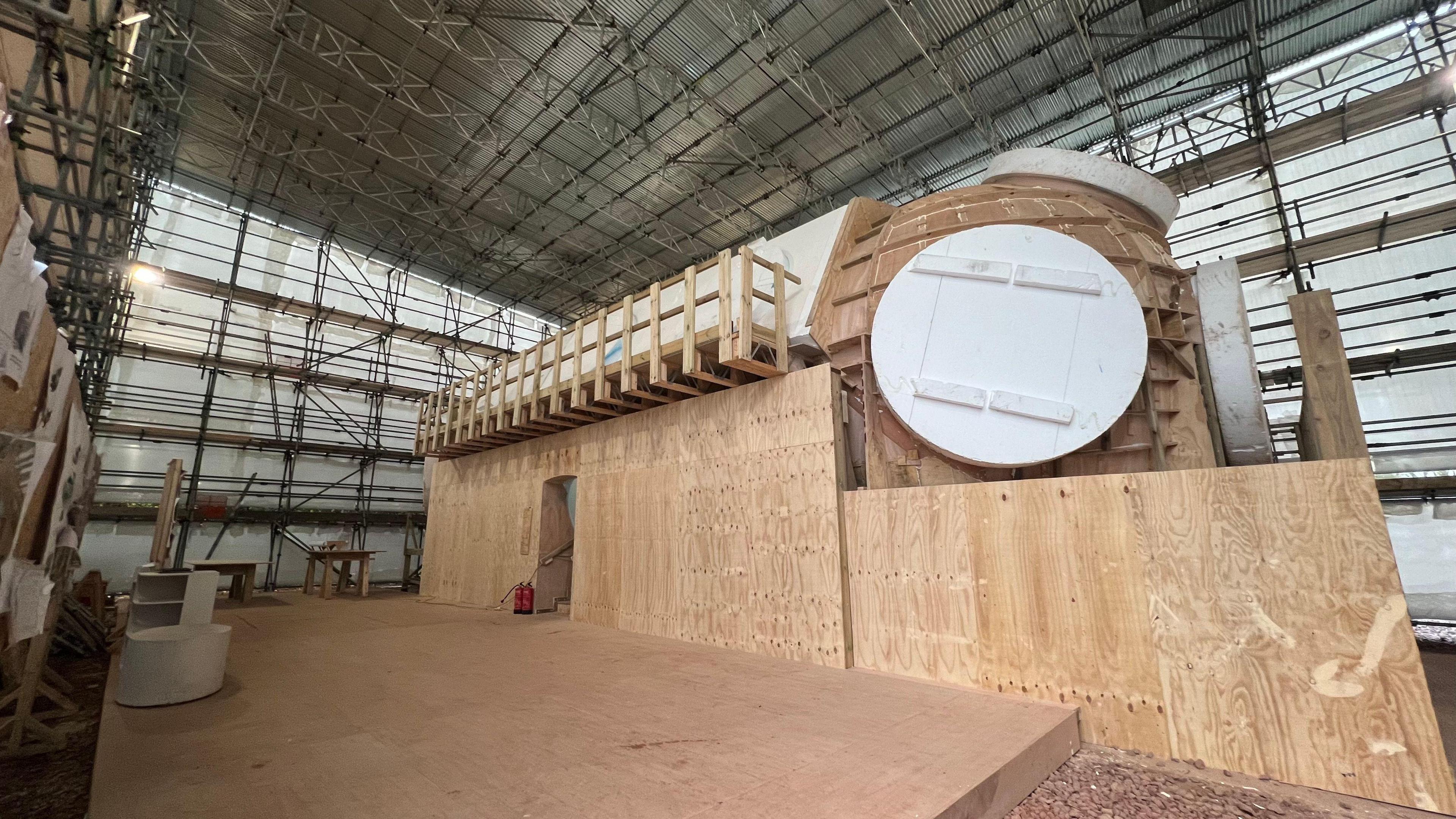 A wooden version of the underwater container in a scaffold building