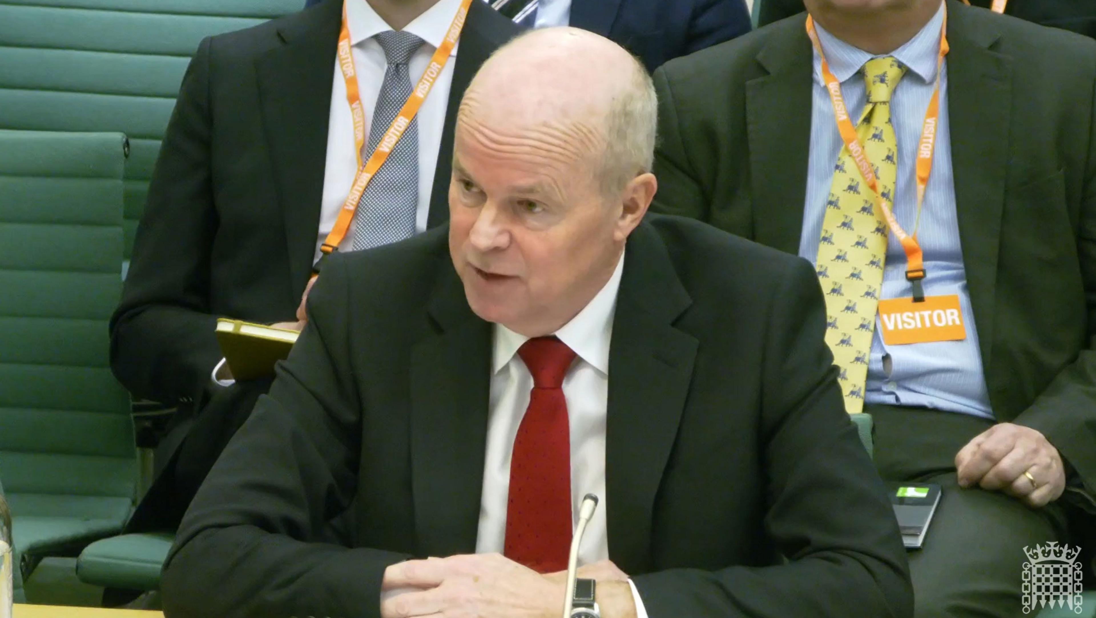 Sir Robbie Gibb in a dark suit and red tie