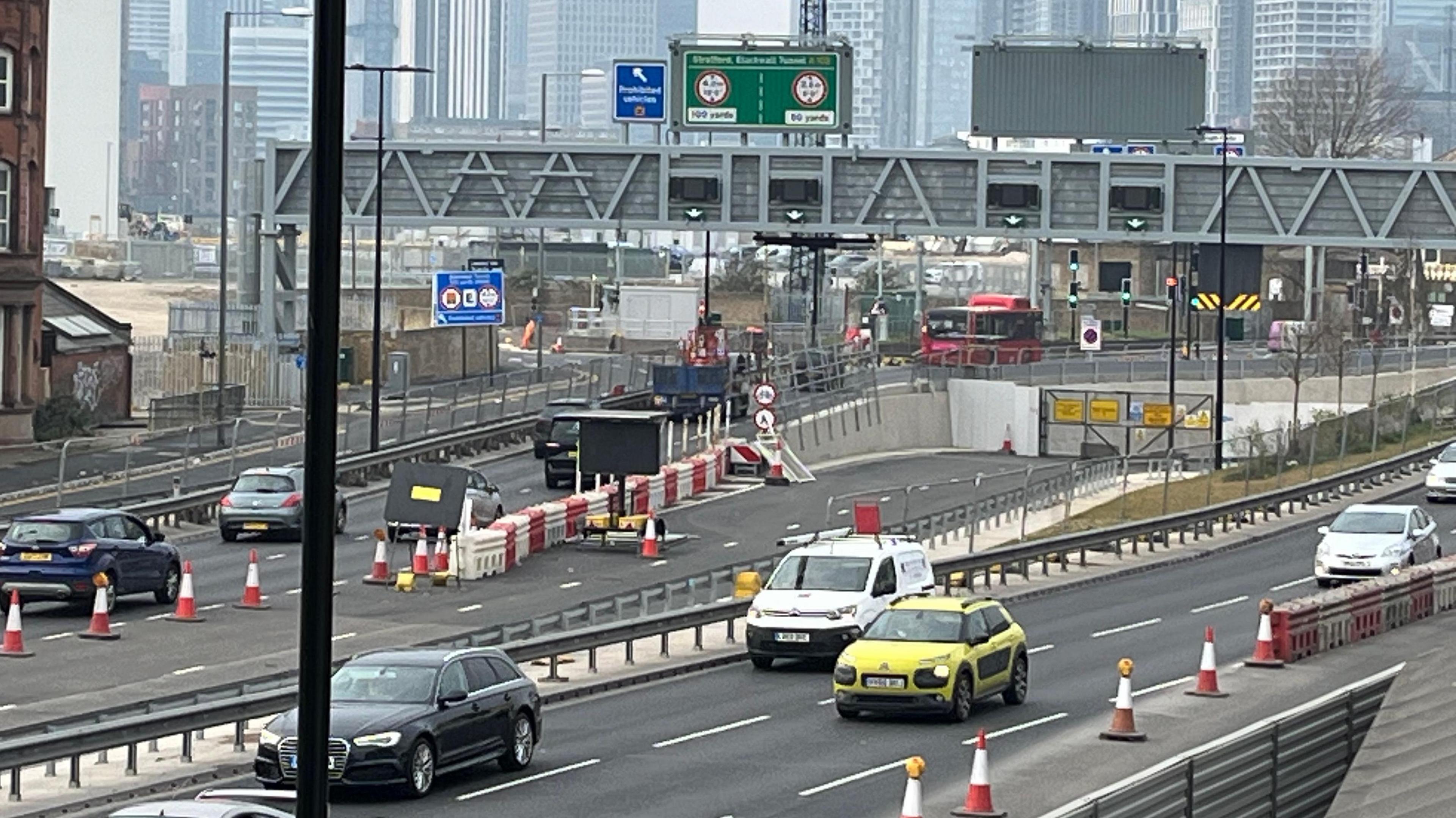 Traffic on a road with an opening into a new tunnel the background