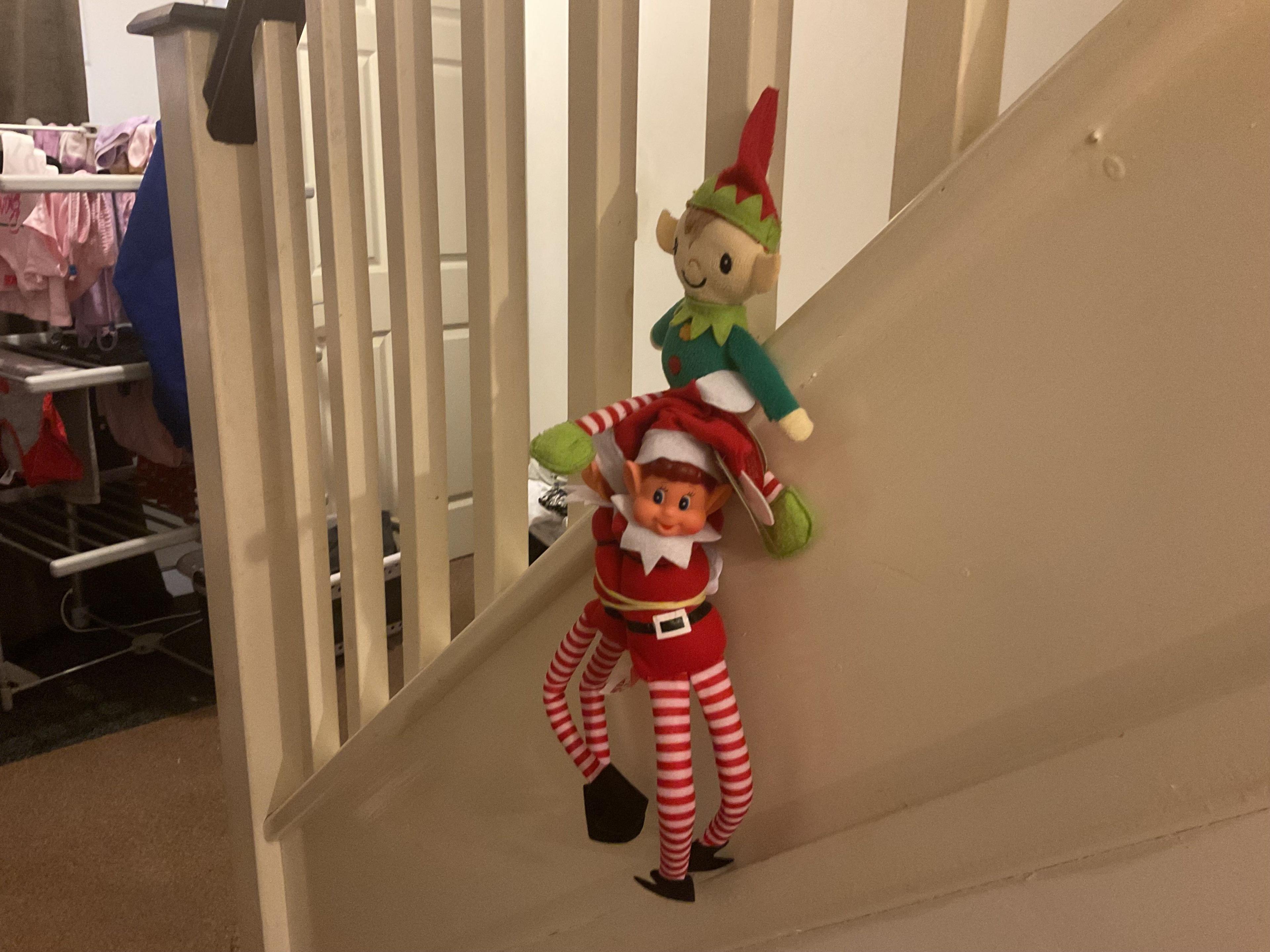 Two elves on the stairs bannister.